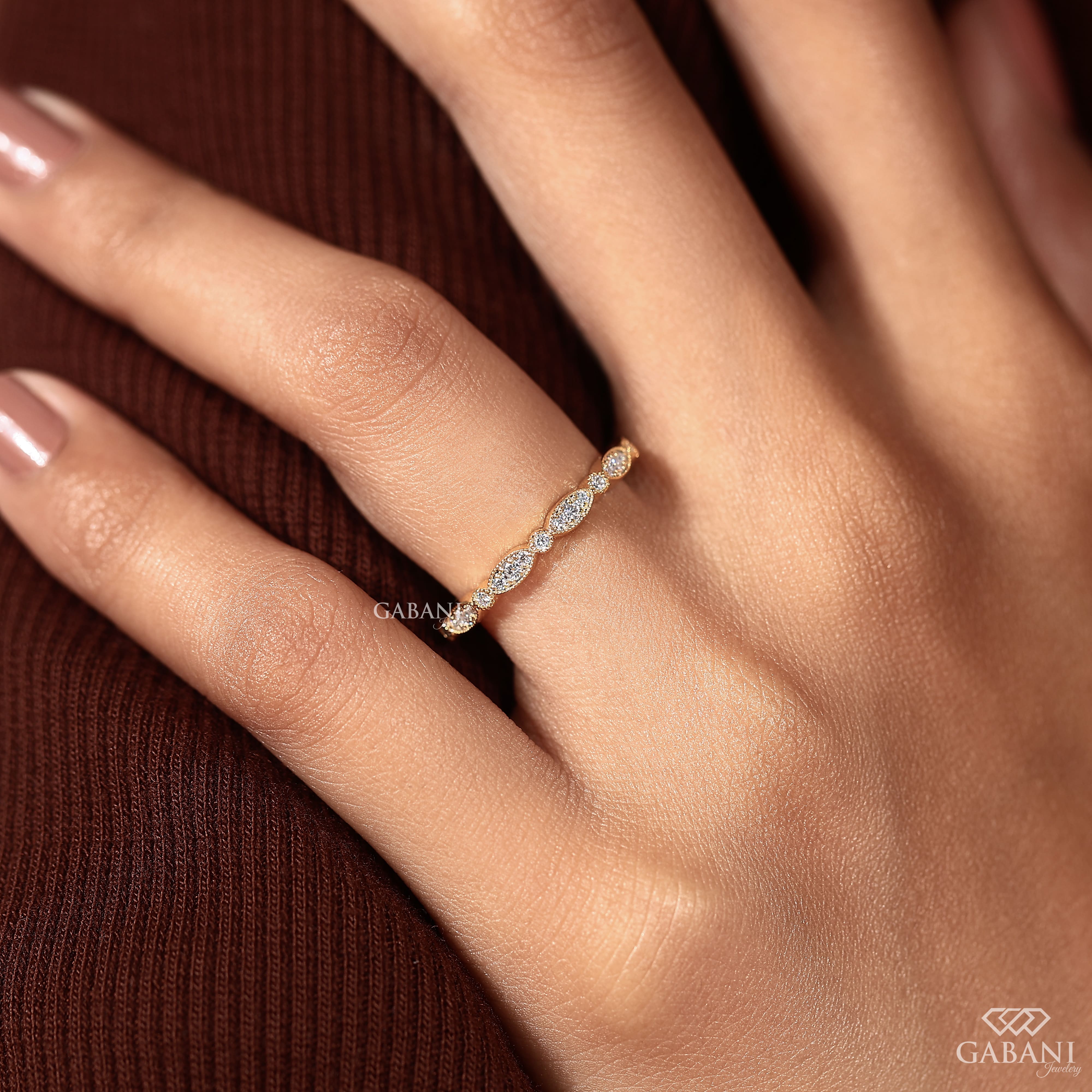 a round cut lab grown diamond wedding band in 14K yellow gold, featuring marquise-inspired diamond clusters, delicate milgrain detailing and a vintage design by Gabani Jewelry.