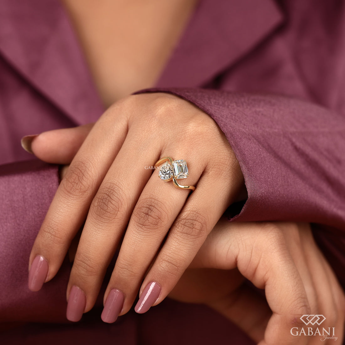 Pear and emerald cut lab grown diamond Toi et Moi ring with a curved yellow gold band, designed for engagement, anniversary, proposal, and statement wear.