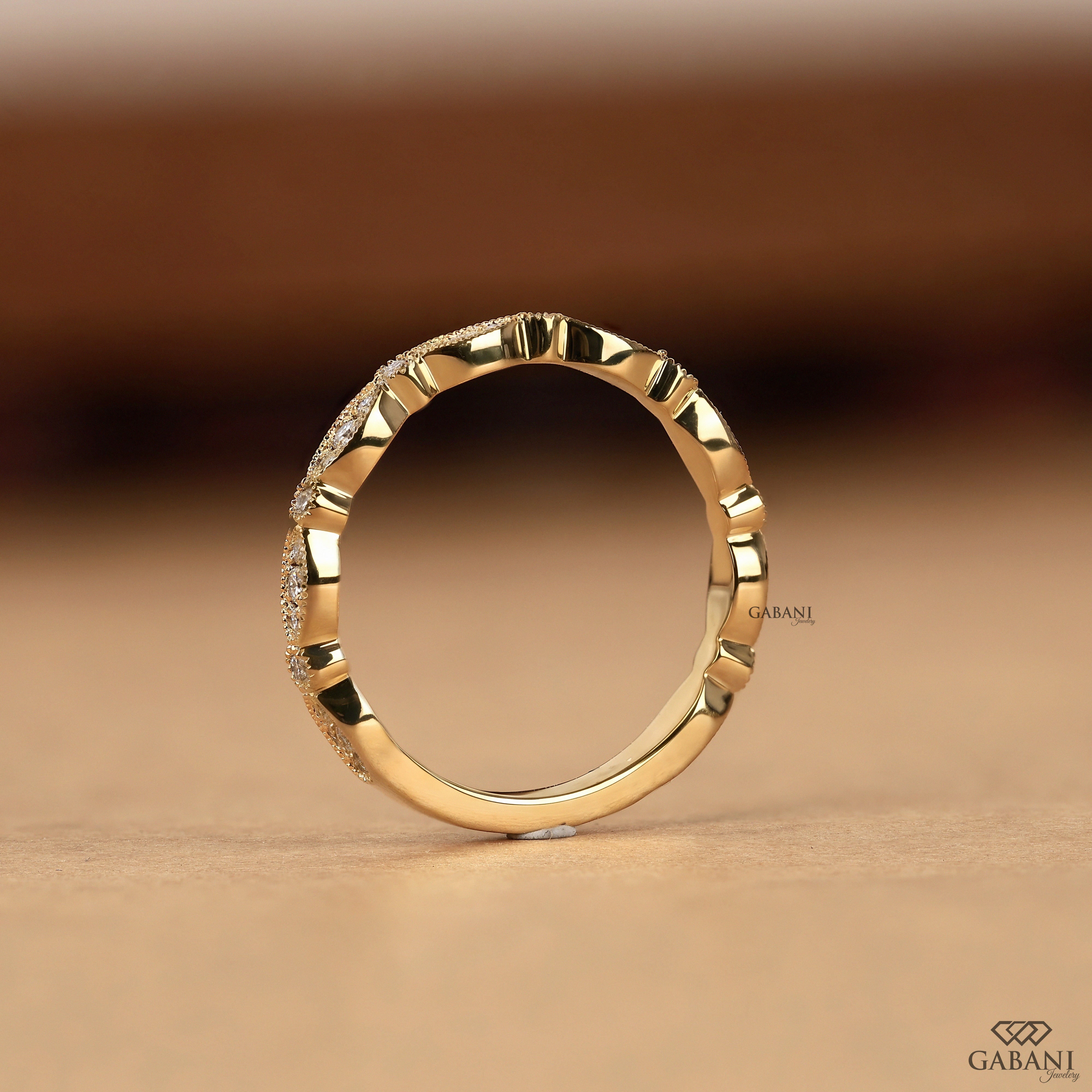 a round cut lab grown diamond wedding band in 14K yellow gold, featuring marquise-inspired diamond clusters, delicate milgrain detailing and a vintage design by Gabani Jewelry.