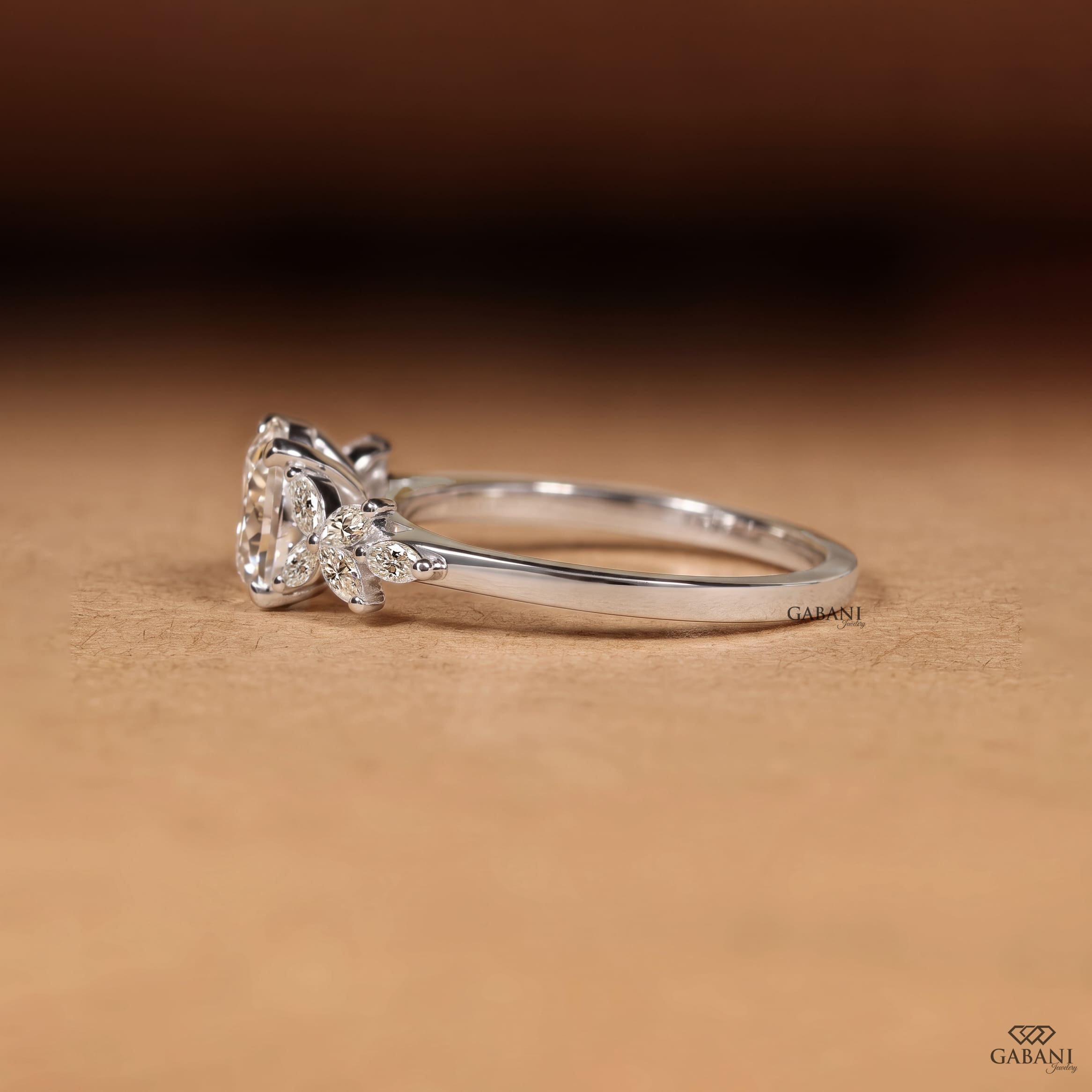 Round Portuguese cut lab grown diamond engagement ring with marquise leaf side stones in polished white gold.