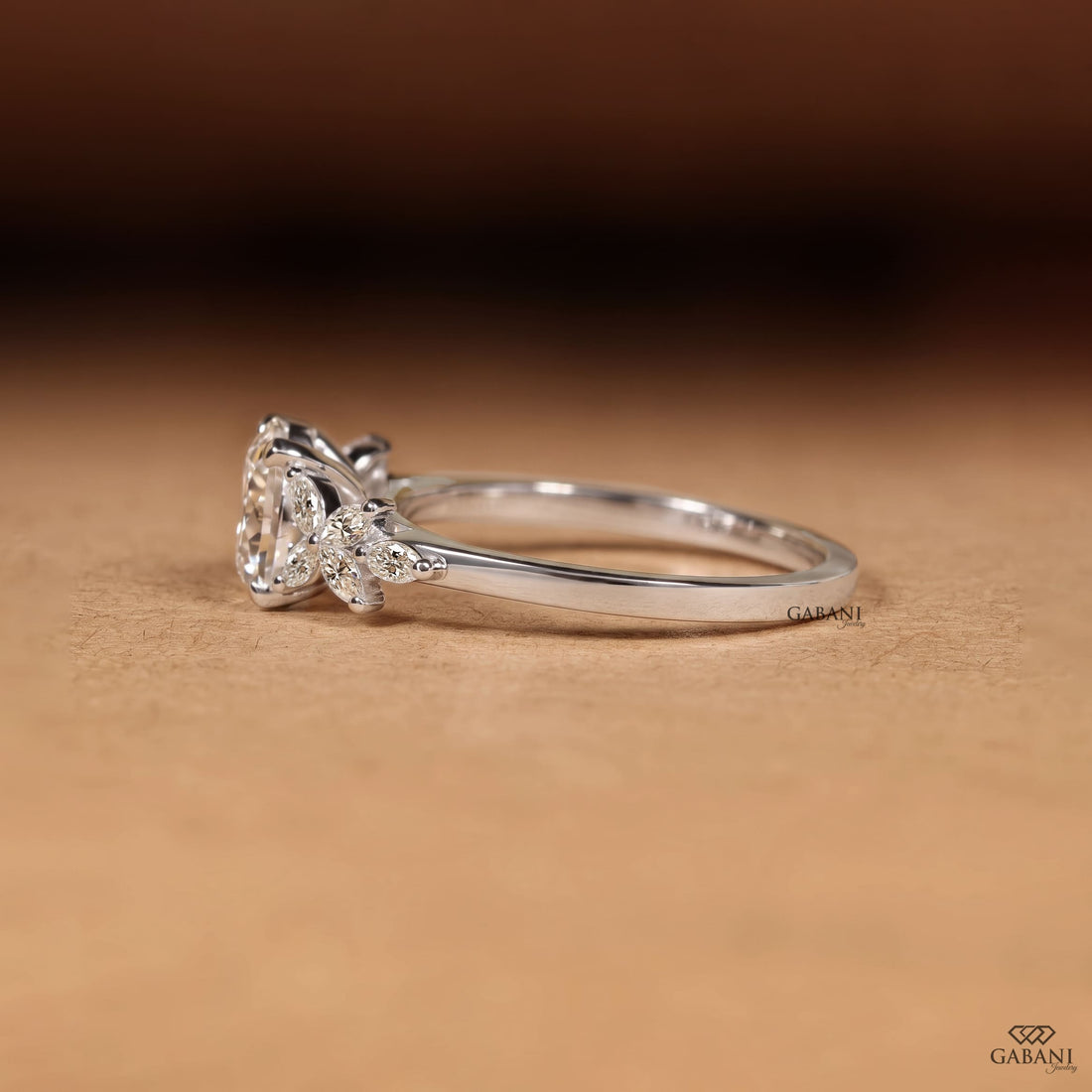 Round Portuguese cut lab grown diamond engagement ring with marquise leaf side stones in polished white gold.