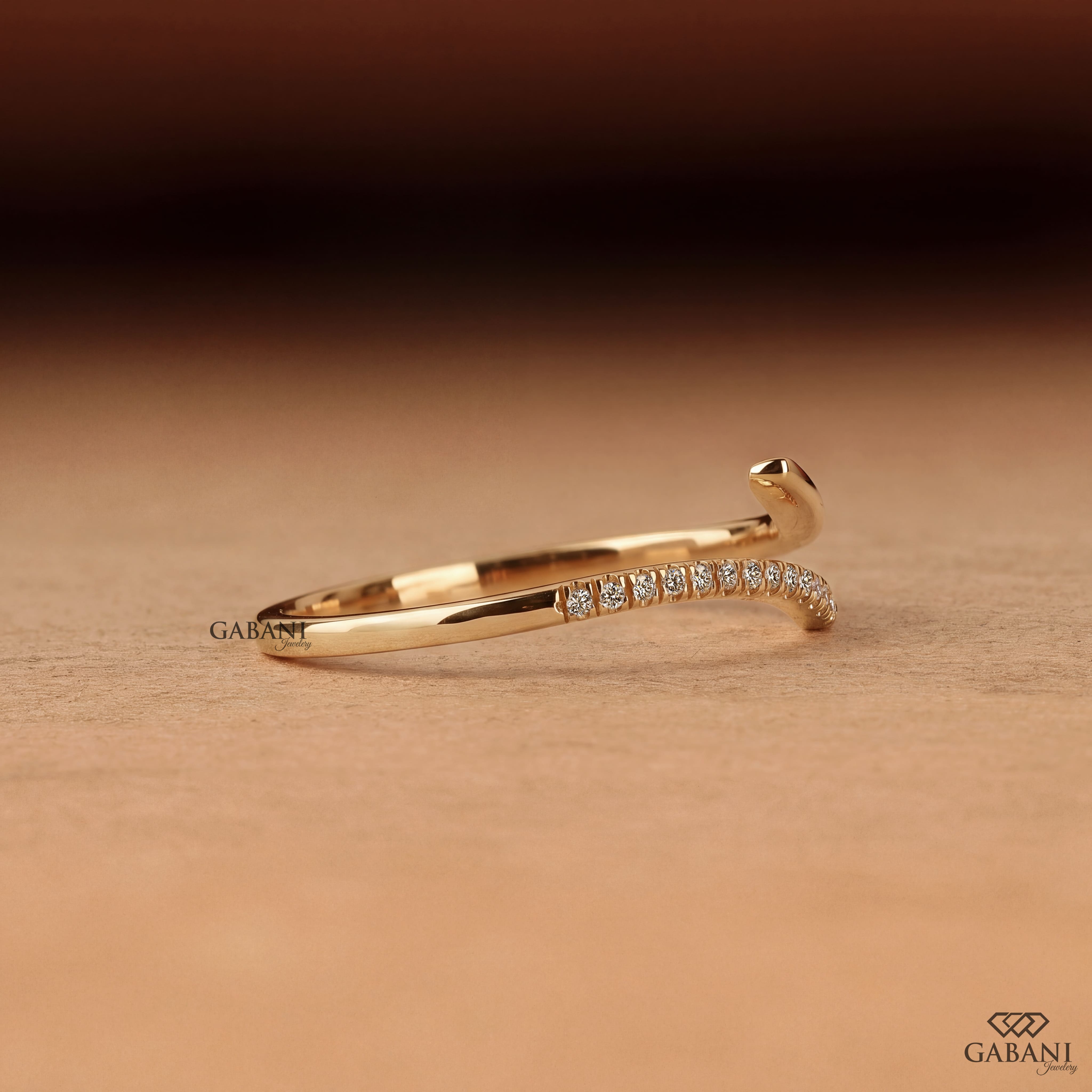 a round lab grown diamond open cuff bangle bracelet in 14K yellow gold, featuring sparkling round diamonds along one curved end and a smooth polished gold wrap design by Gabani Jewelry.