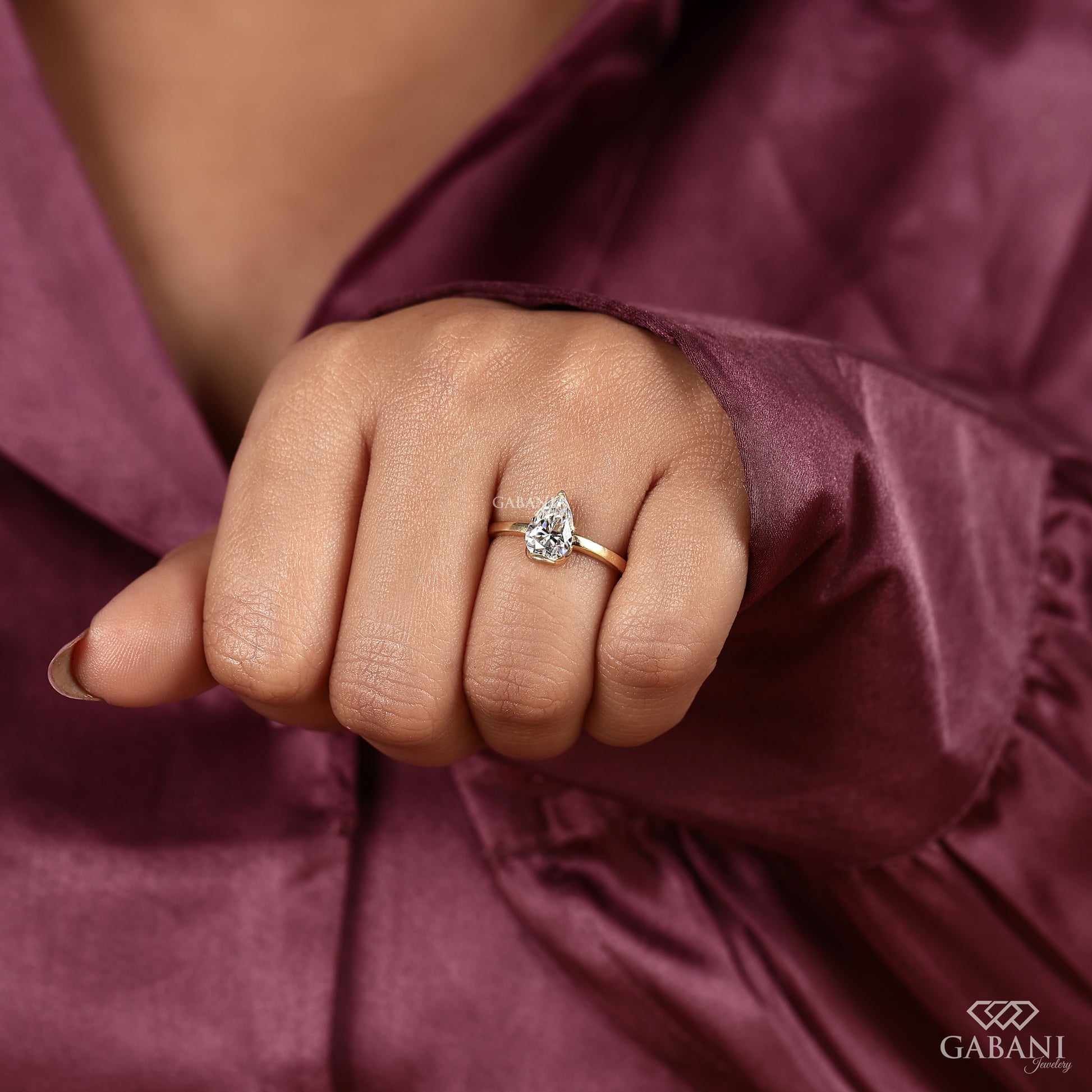 Yellow gold pear cut lab grown diamond ring with half bezel setting
