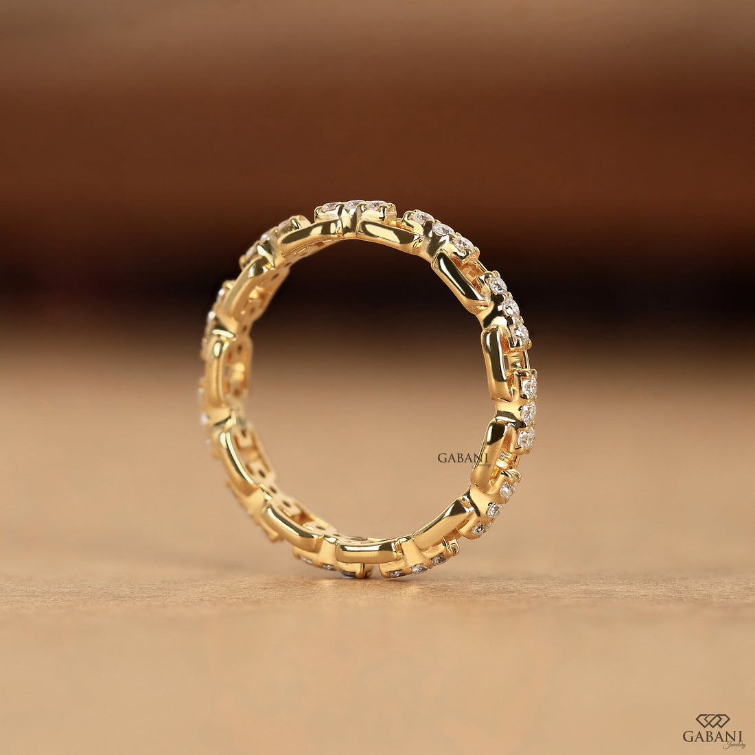 a round lab grown diamond chain link eternity band in 14K yellow gold, featuring prong set diamonds and rectangular gold links.