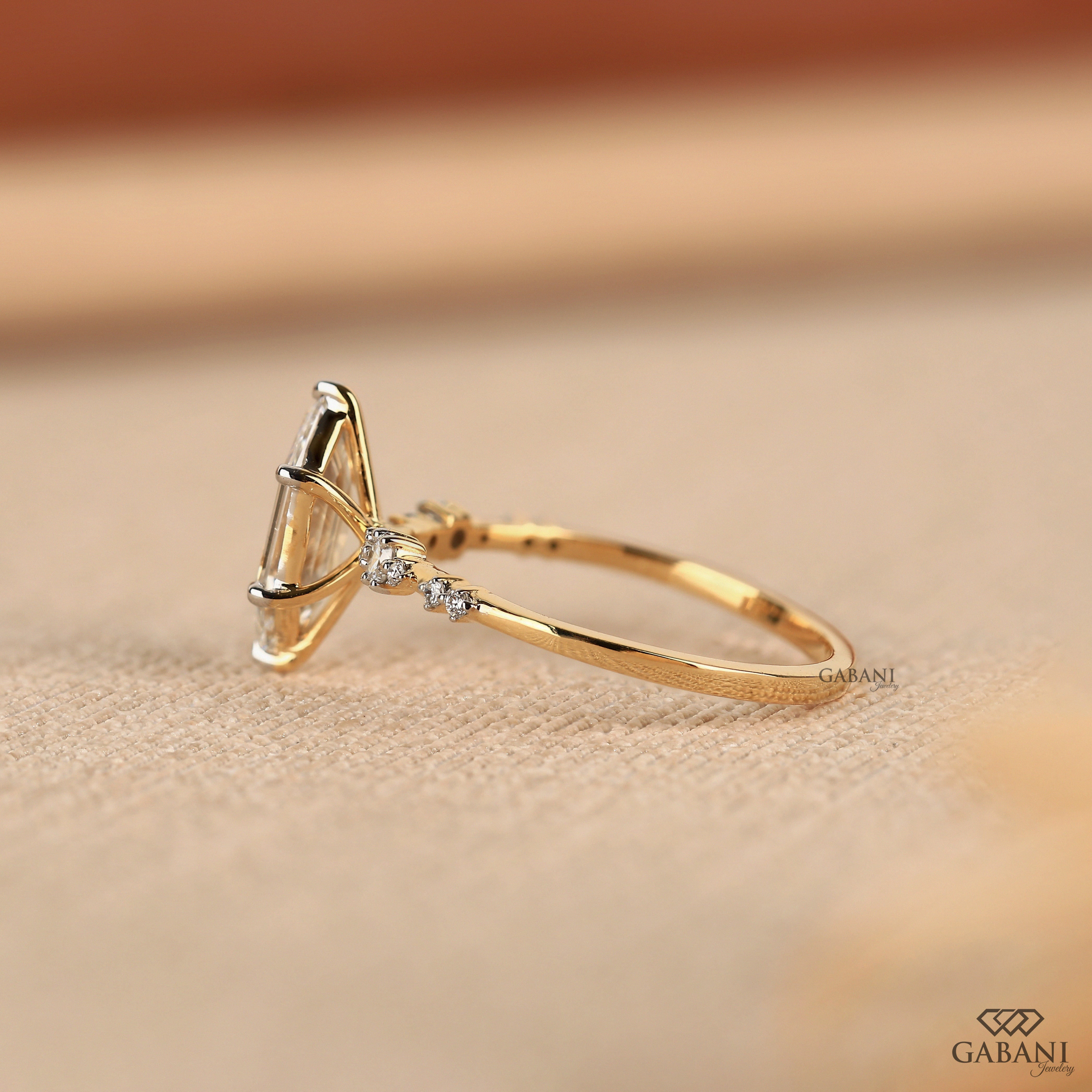 Dutch marquise lab grown diamond engagement ring with elongated geometric center stone, round side diamond accents and gold band.