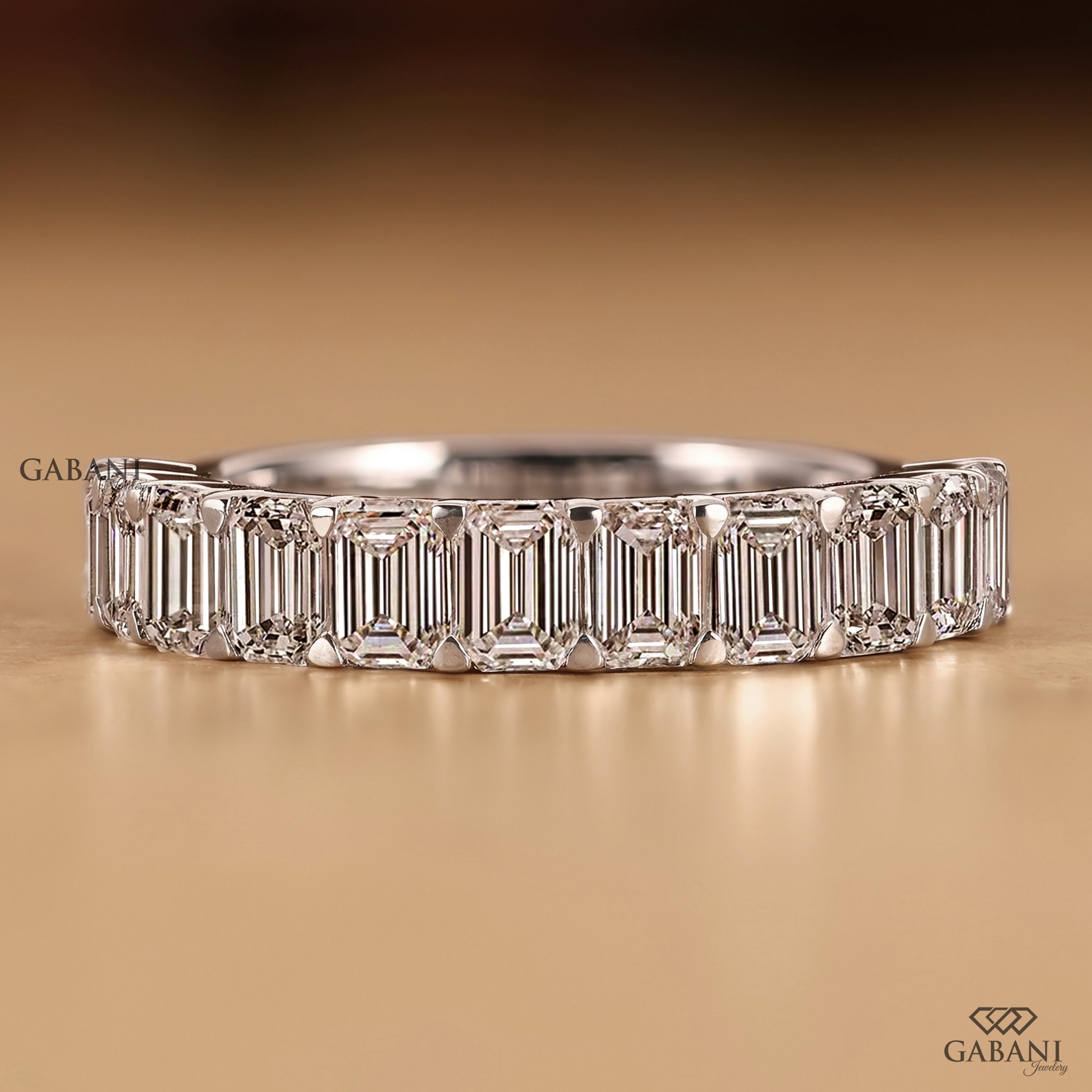 Front view of a Gabani Jewelry emerald cut lab grown diamond half eternity wedding band in polished white gold