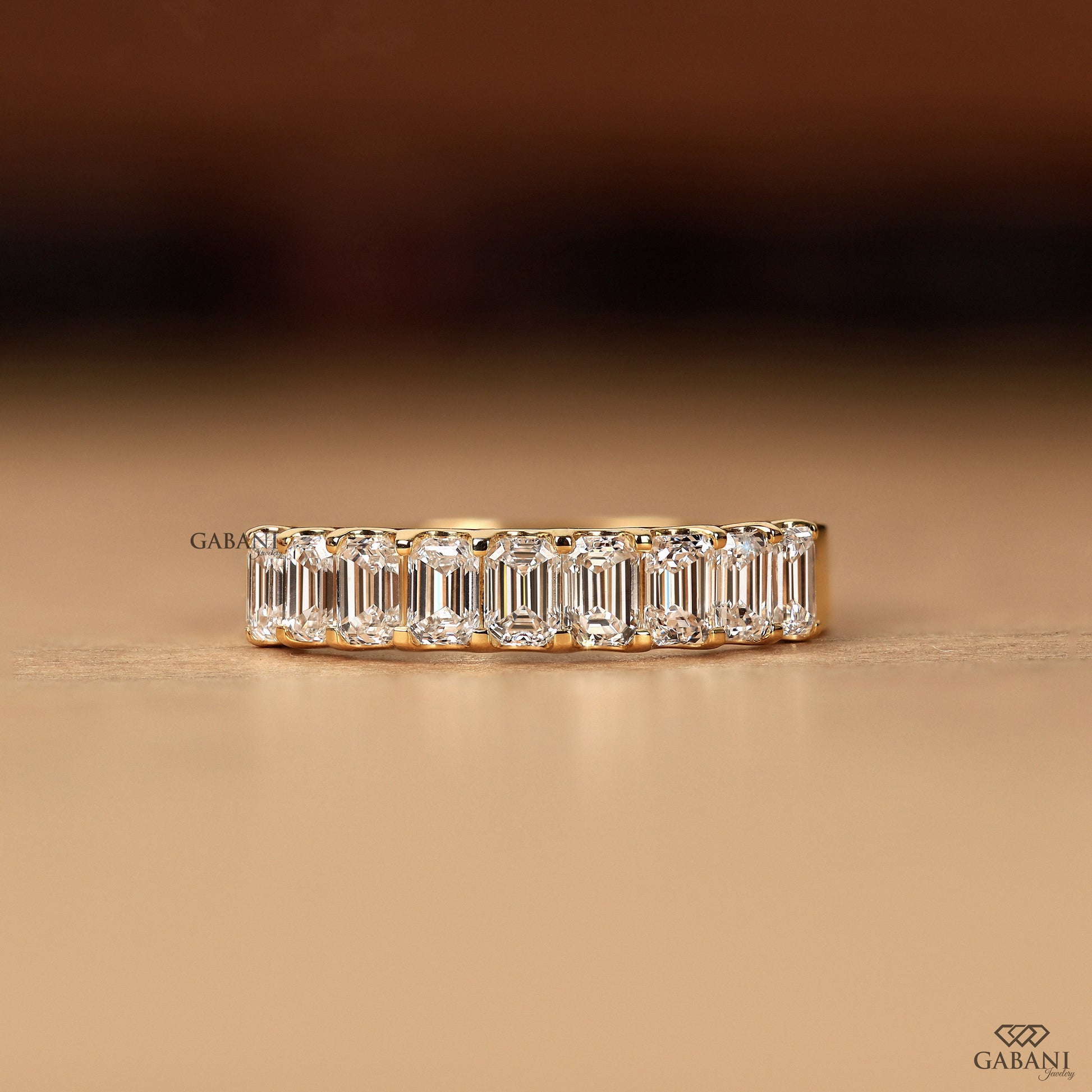 emerald cut lab grown diamond band in yellow gold half eternity design with 9 stones and comfort fit
