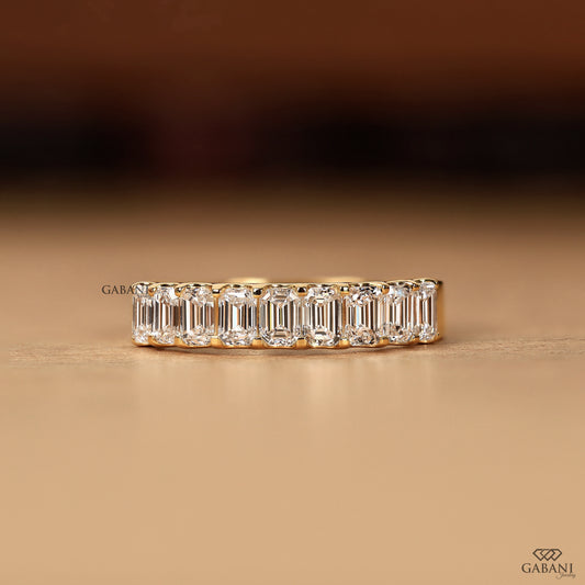 emerald cut lab grown diamond band in yellow gold half eternity design with 9 stones and comfort fit
