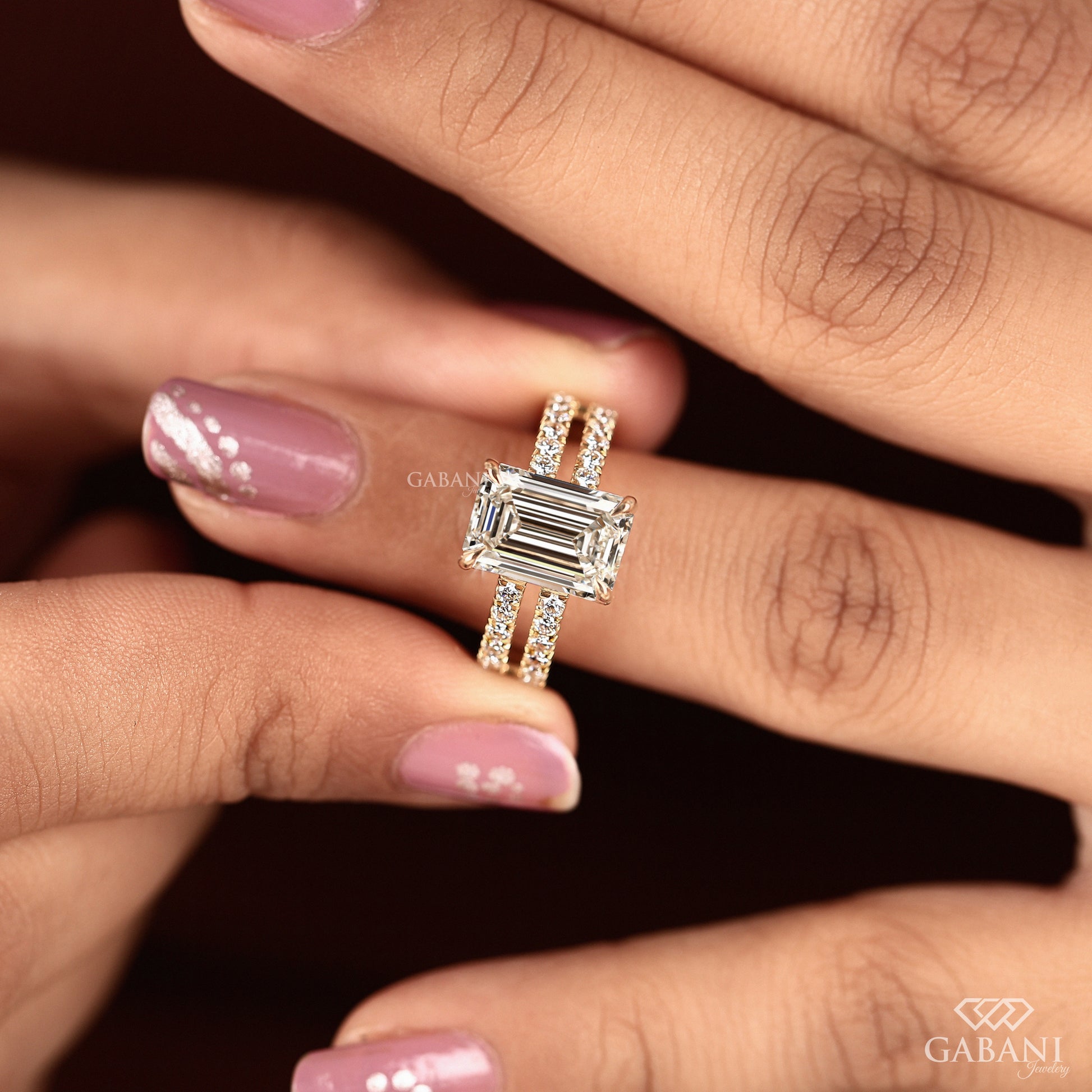 Yellow gold double shank ring with emerald cut center diamond
