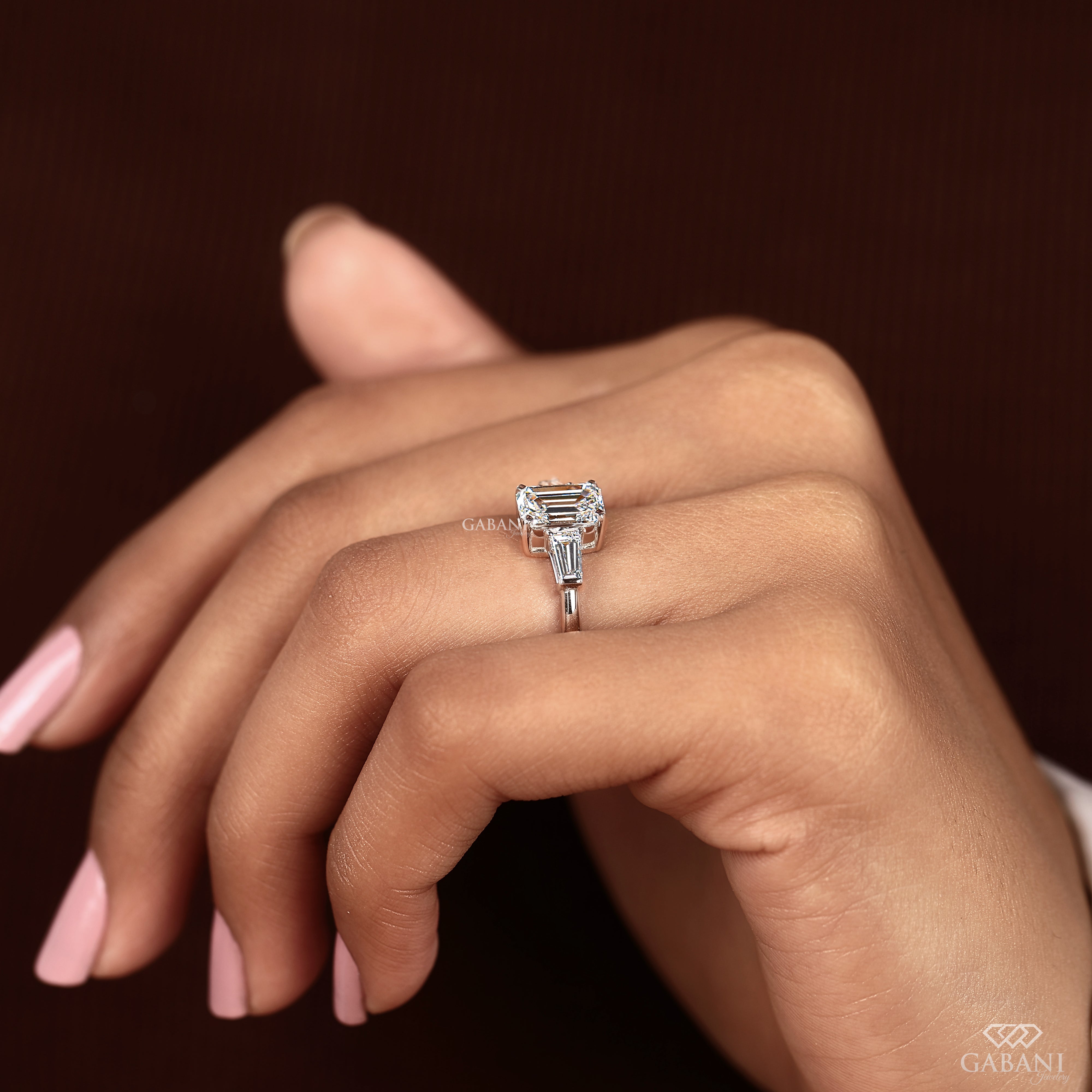 Three stone lab grown diamond engagement ring with emerald cut center