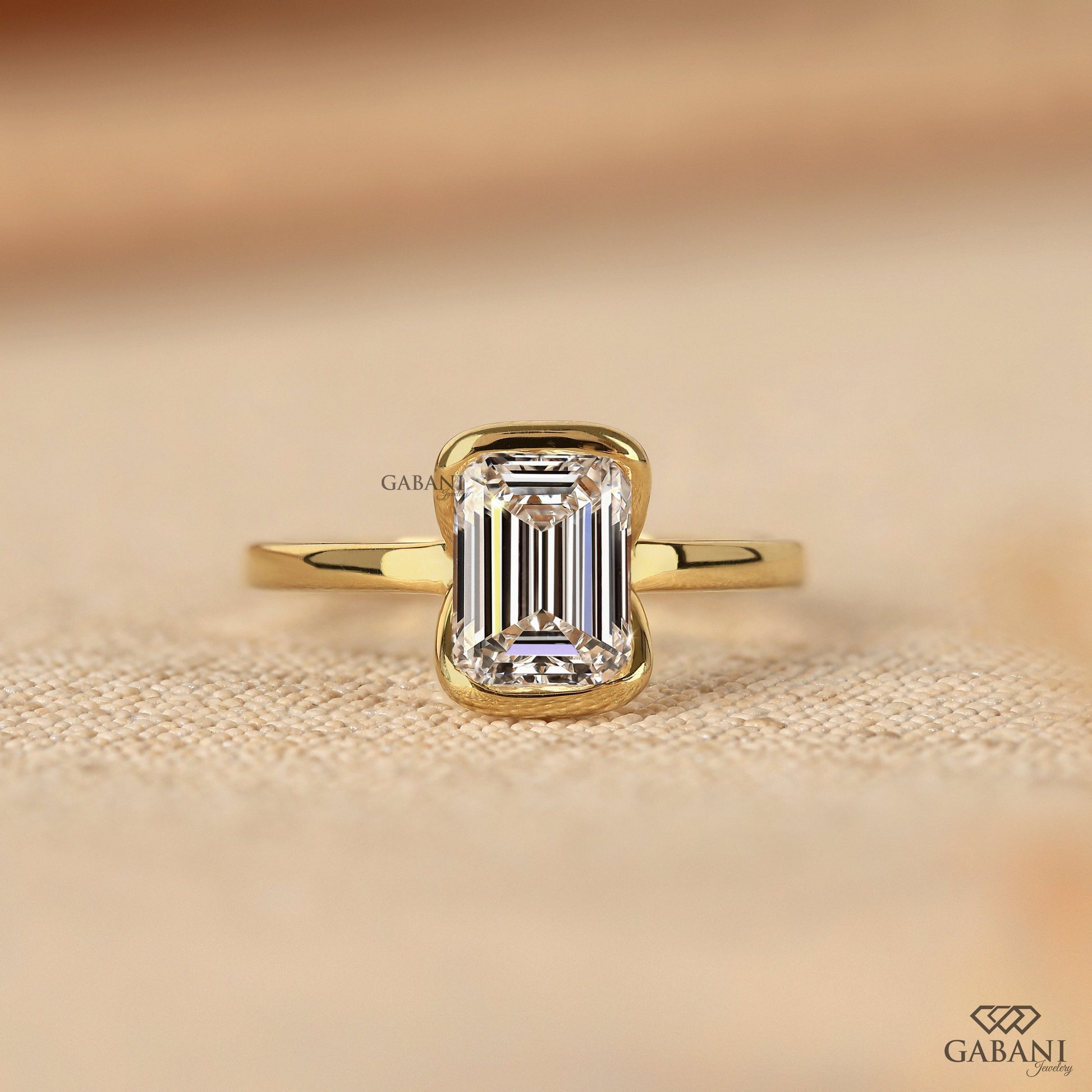 emerald cut lab grown diamond solitaire ring in yellow gold with half bezel setting