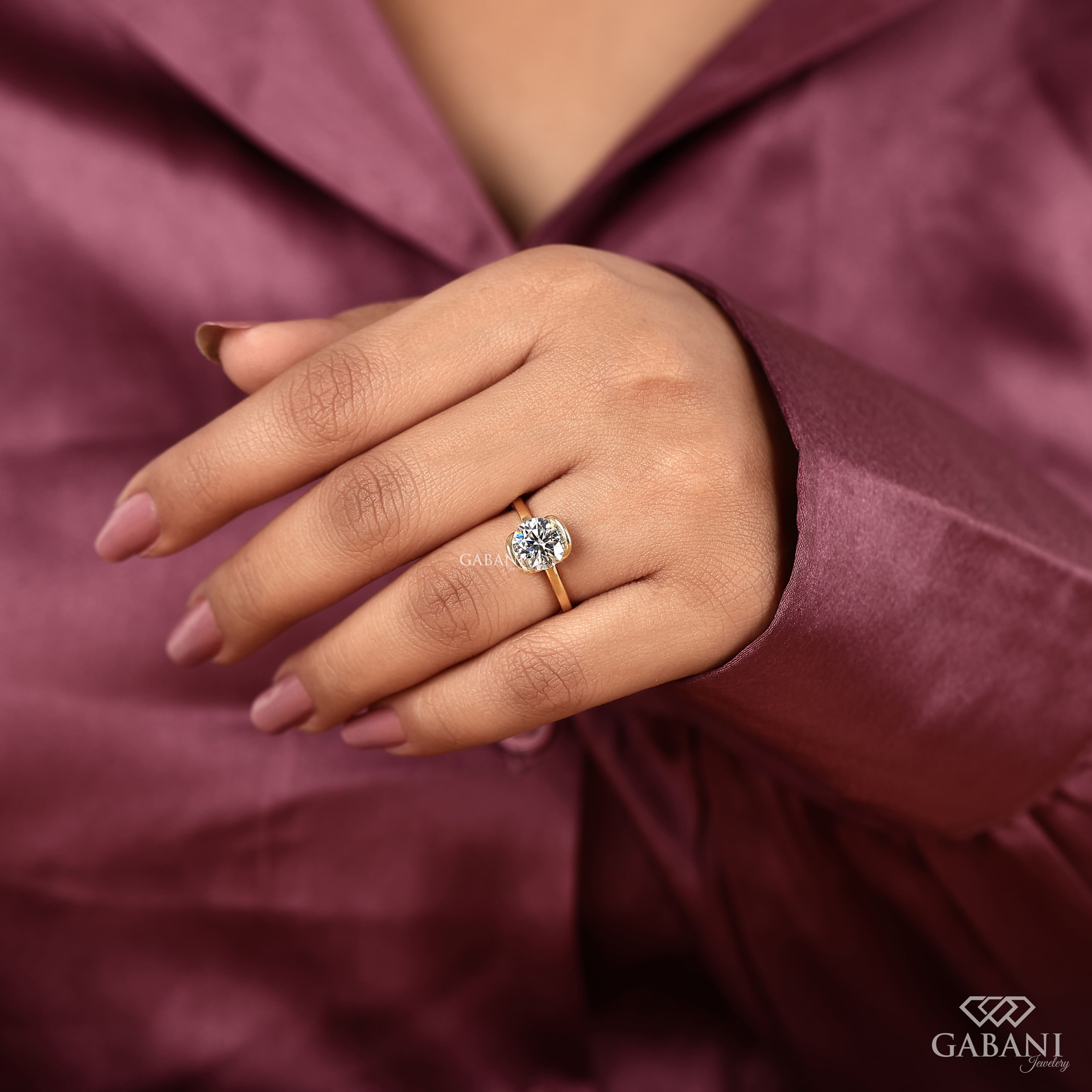 Round diamond half bezel solitaire engagement ring in yellow gold with a slim straight polished band.