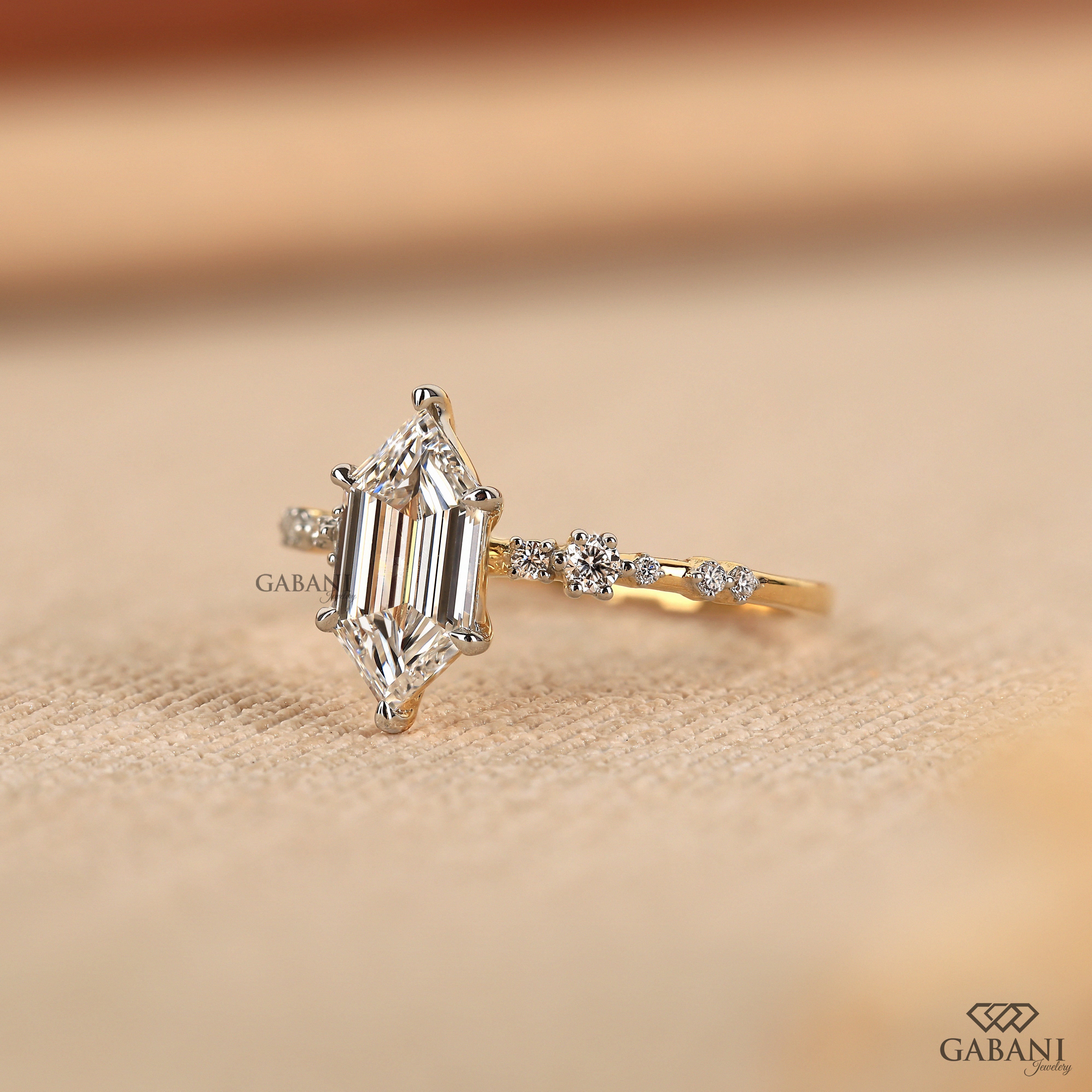Dutch marquise lab grown diamond engagement ring with elongated geometric center stone, round side diamond accents and gold band.