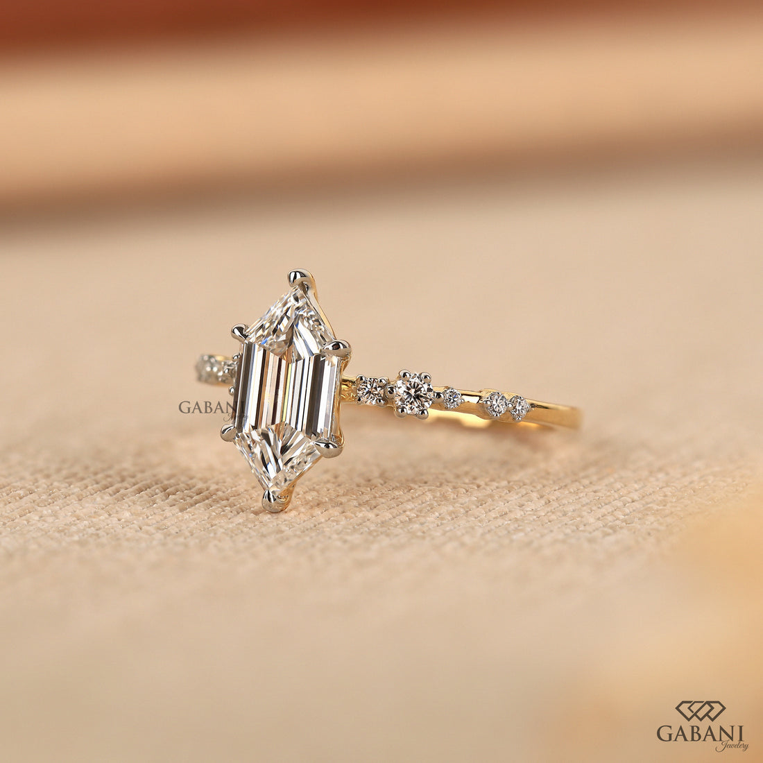 Dutch marquise lab grown diamond engagement ring with elongated geometric center stone, round side diamond accents and gold band.