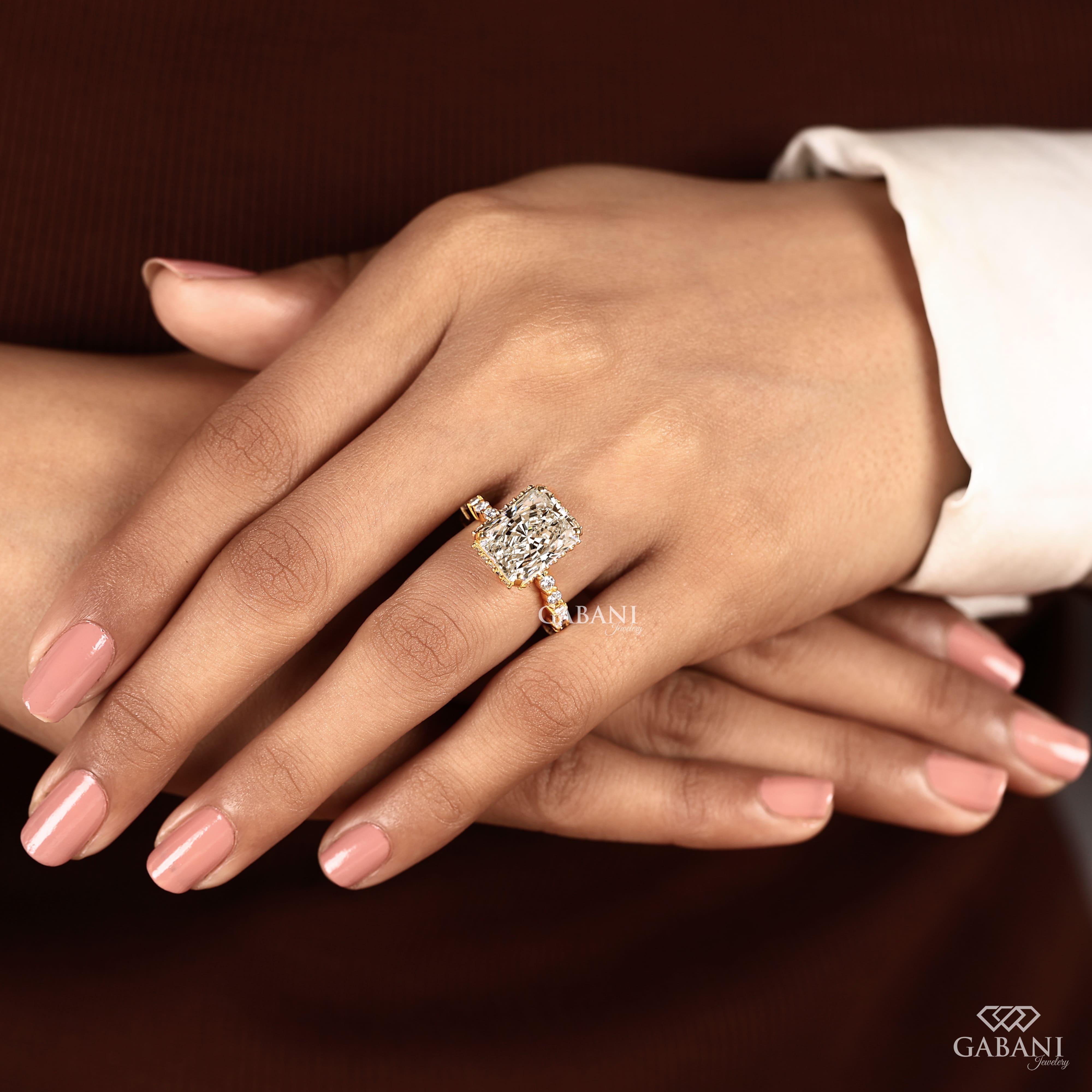 Radiant cut lab grown diamond engagement ring with hidden halo, round and baguette side diamonds, and polished gold band.