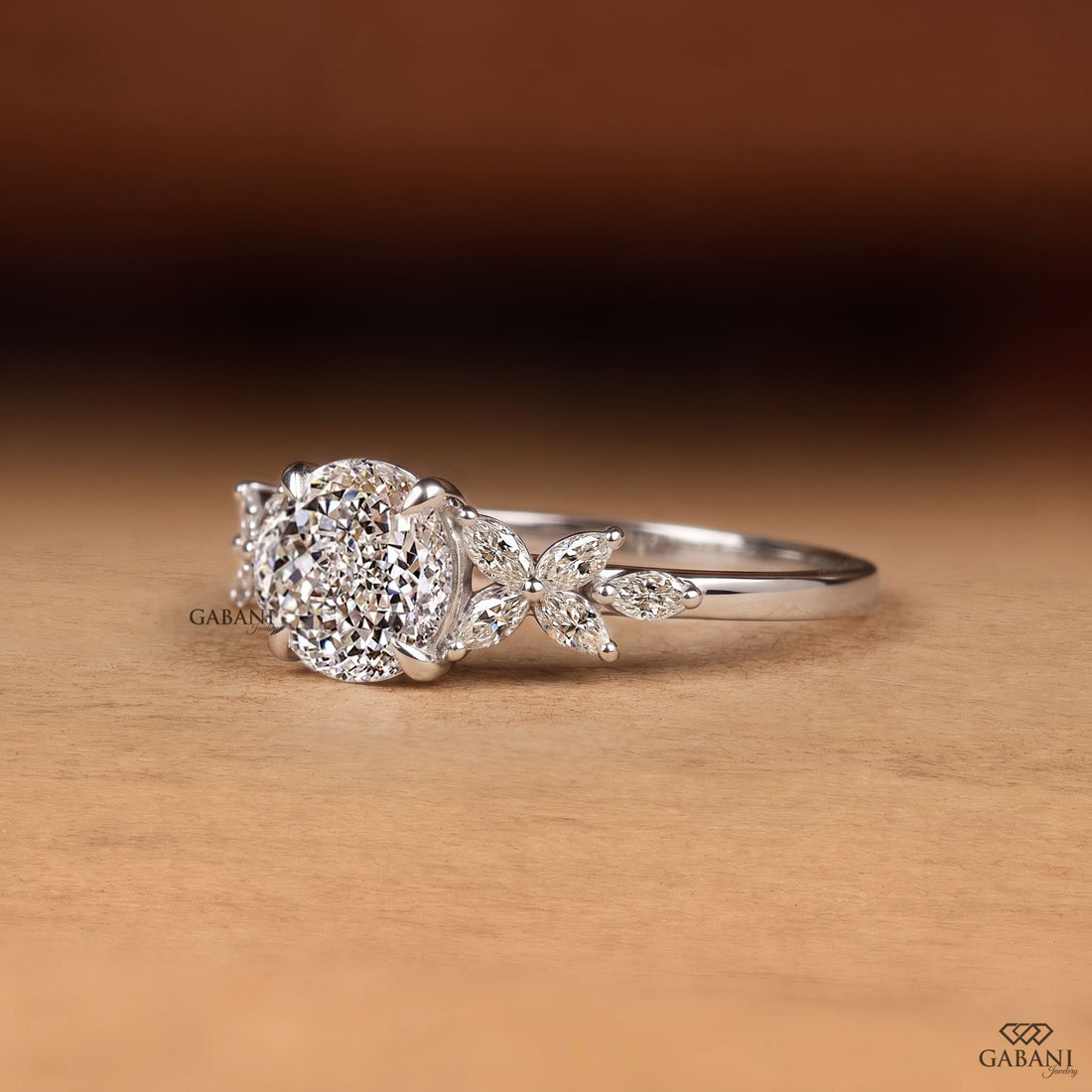 Round Portuguese cut lab grown diamond engagement ring with marquise leaf side stones in polished white gold.