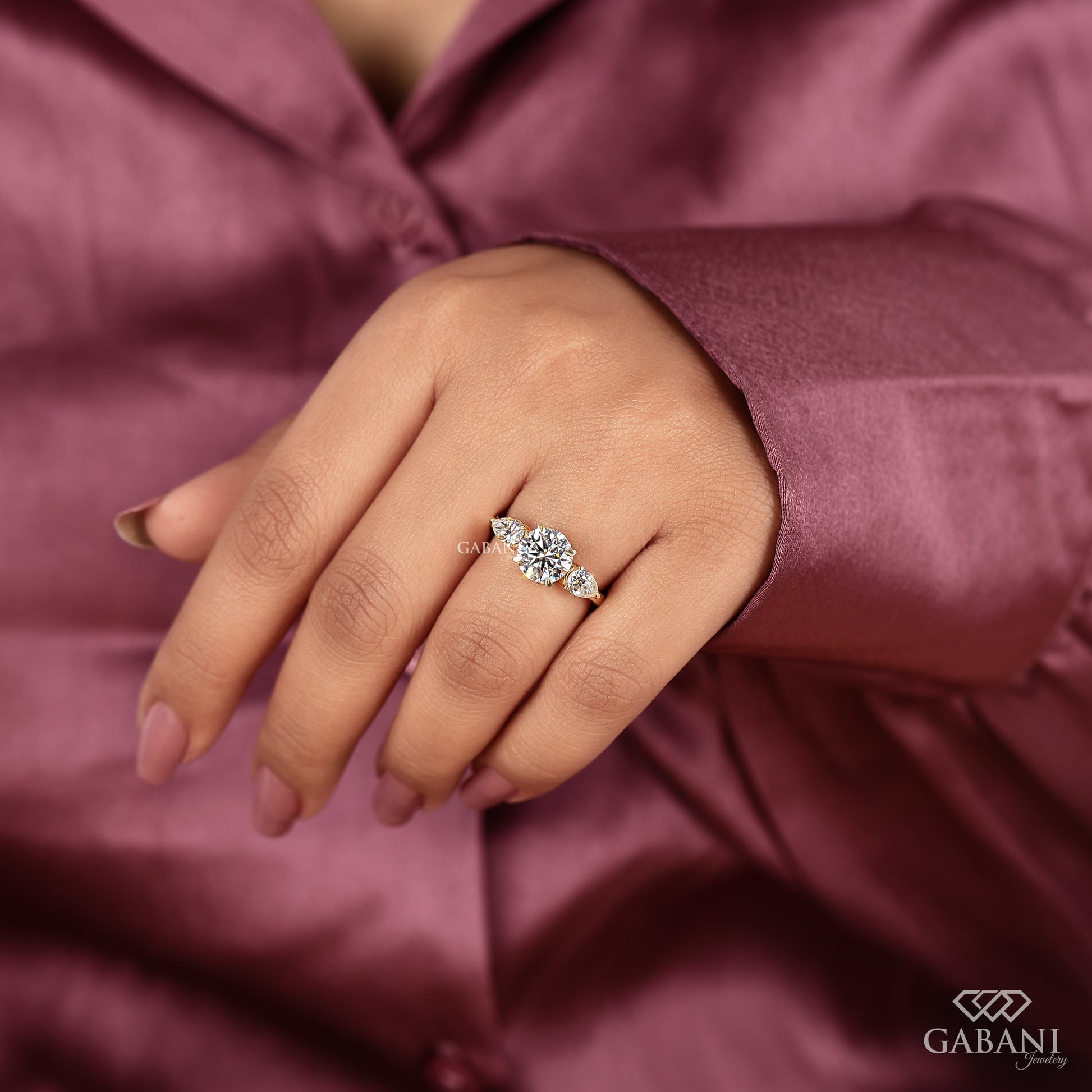 three stone yellow gold ring with round lab grown diamond and pear shaped side stones