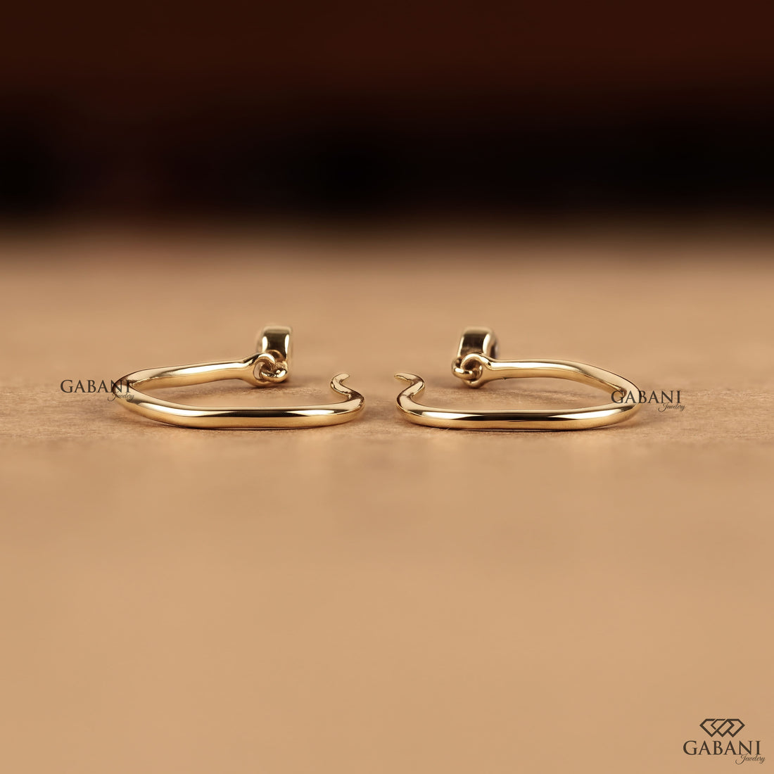 Round cut lab grown diamond hook earrings with 0.10 CTW, bezel set stones and a slim curved gold drop design for everyday wear.