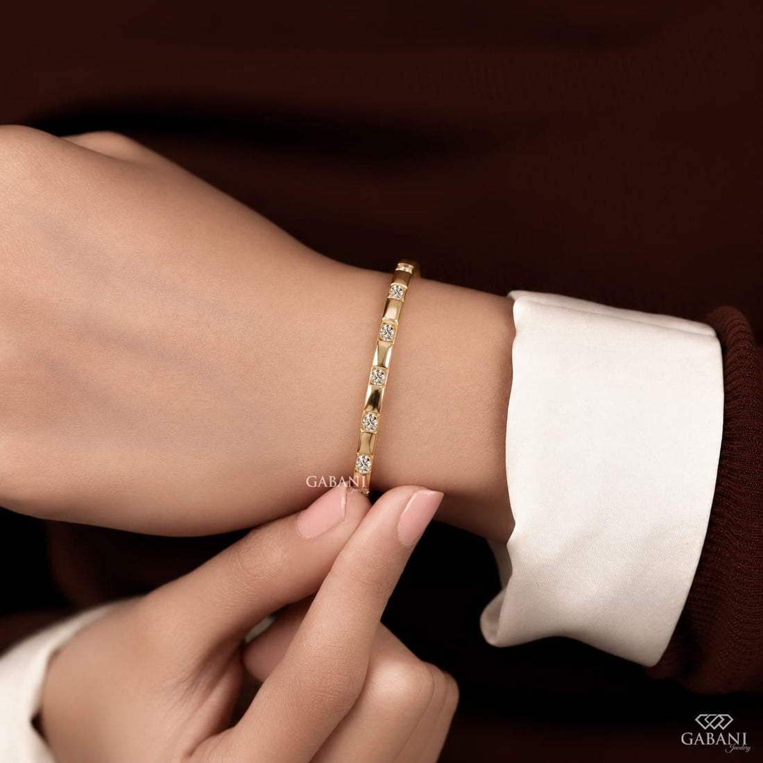 a round lab grown diamond bangle bracelet in yellow gold, featuring evenly spaced sparkling diamonds between polished gold bars in a modern geometric design by Gabani Jewelry.
