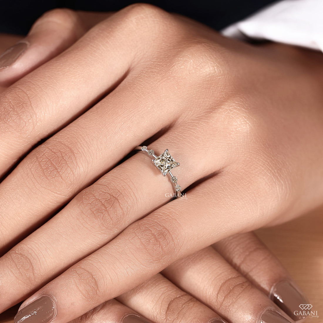 Princess cut lab grown diamond engagement ring in white gold with a four prong center setting and spaced round diamond side stones along the polished band.
