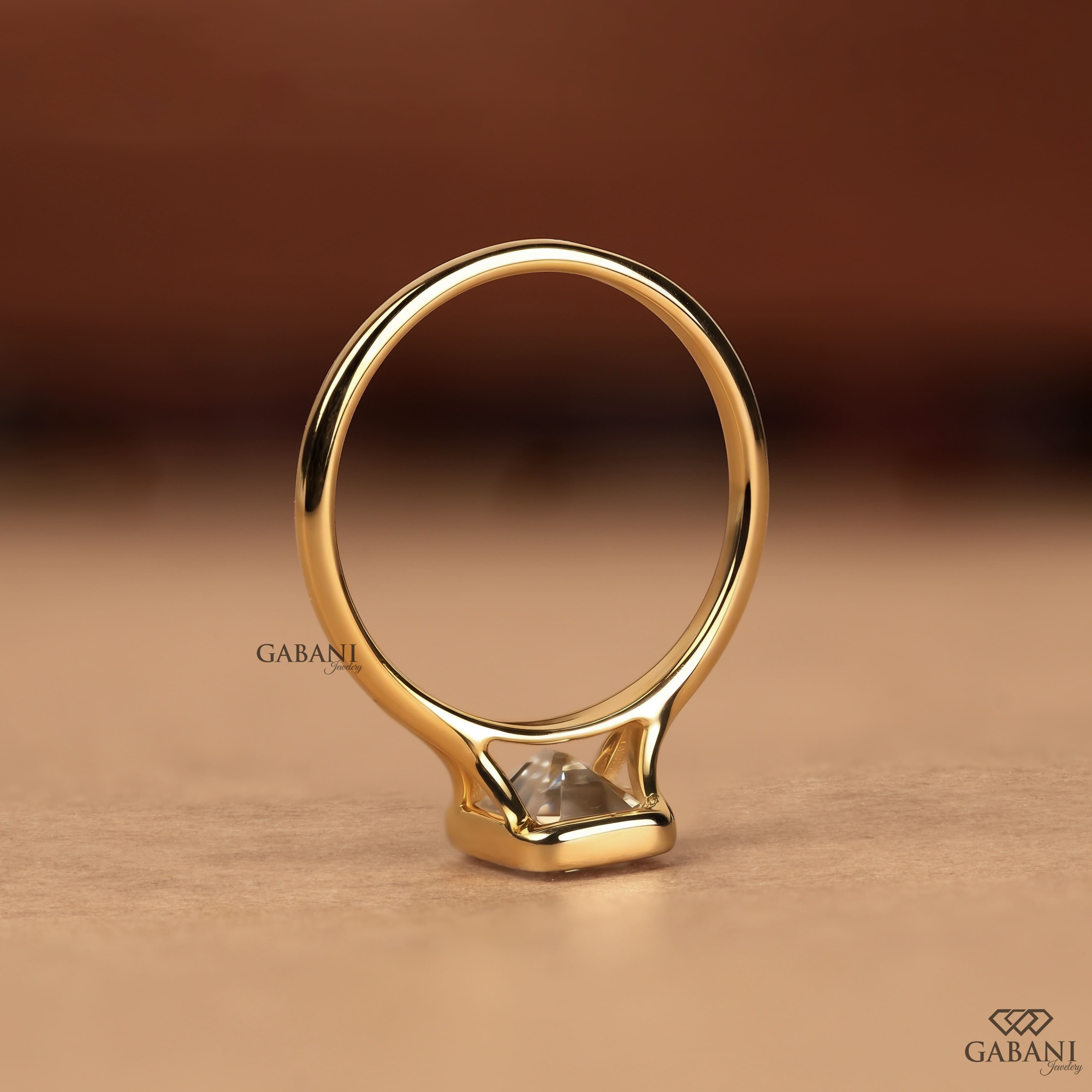 emerald cut diamond solitaire engagement ring with full bezel setting in yellow gold