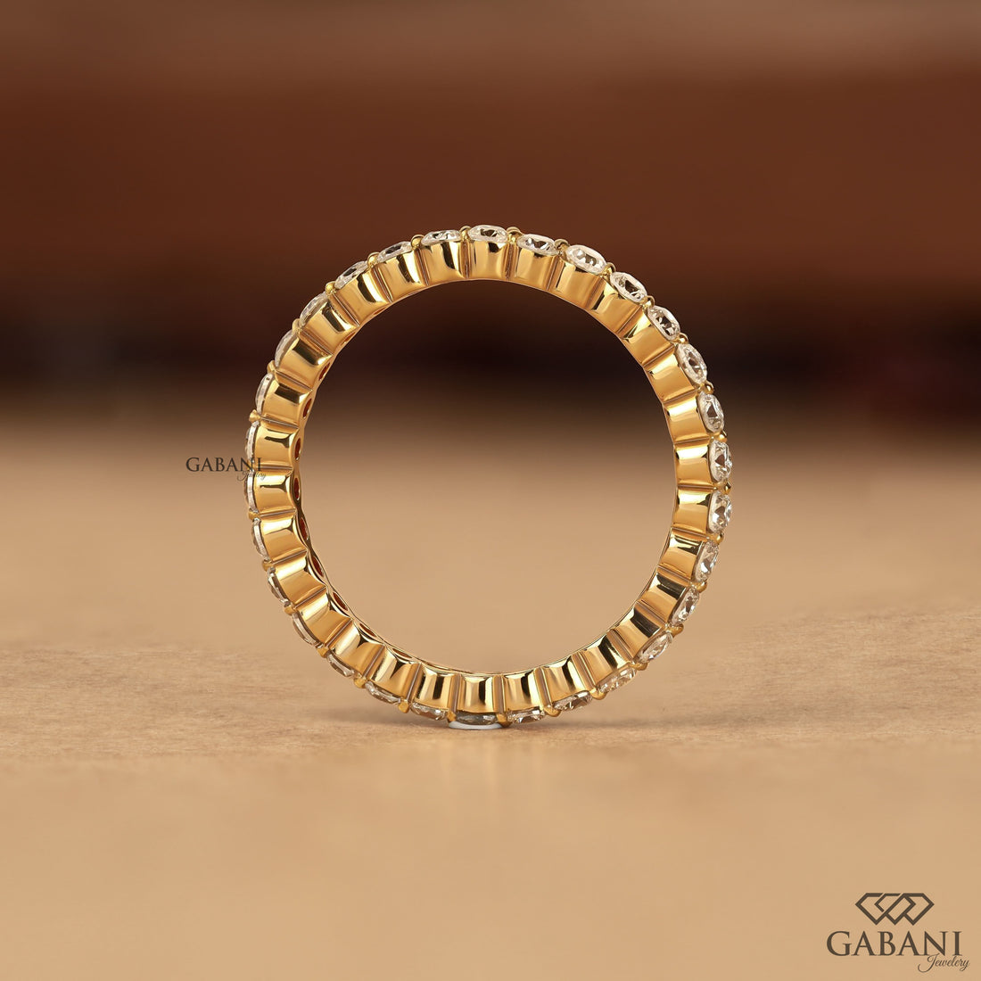 Round cut lab grown diamond full eternity wedding band in yellow gold with shared prong setting and continuous diamond design.