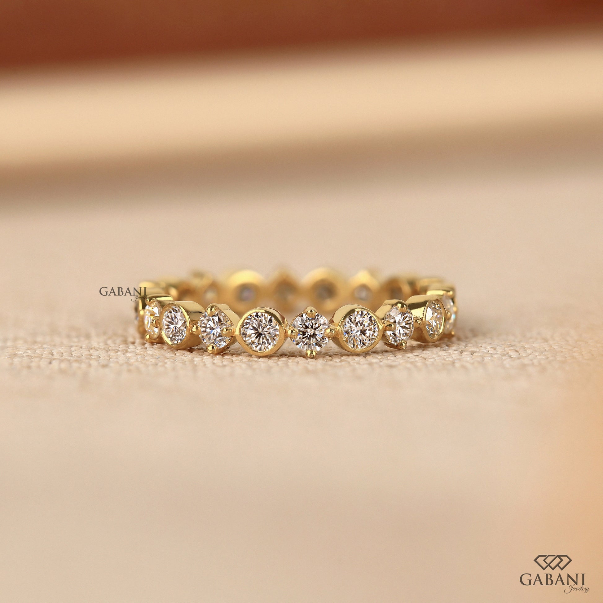 bezel set round lab grown diamond wedding band in 14k yellow gold with full eternity design and smooth polished finish