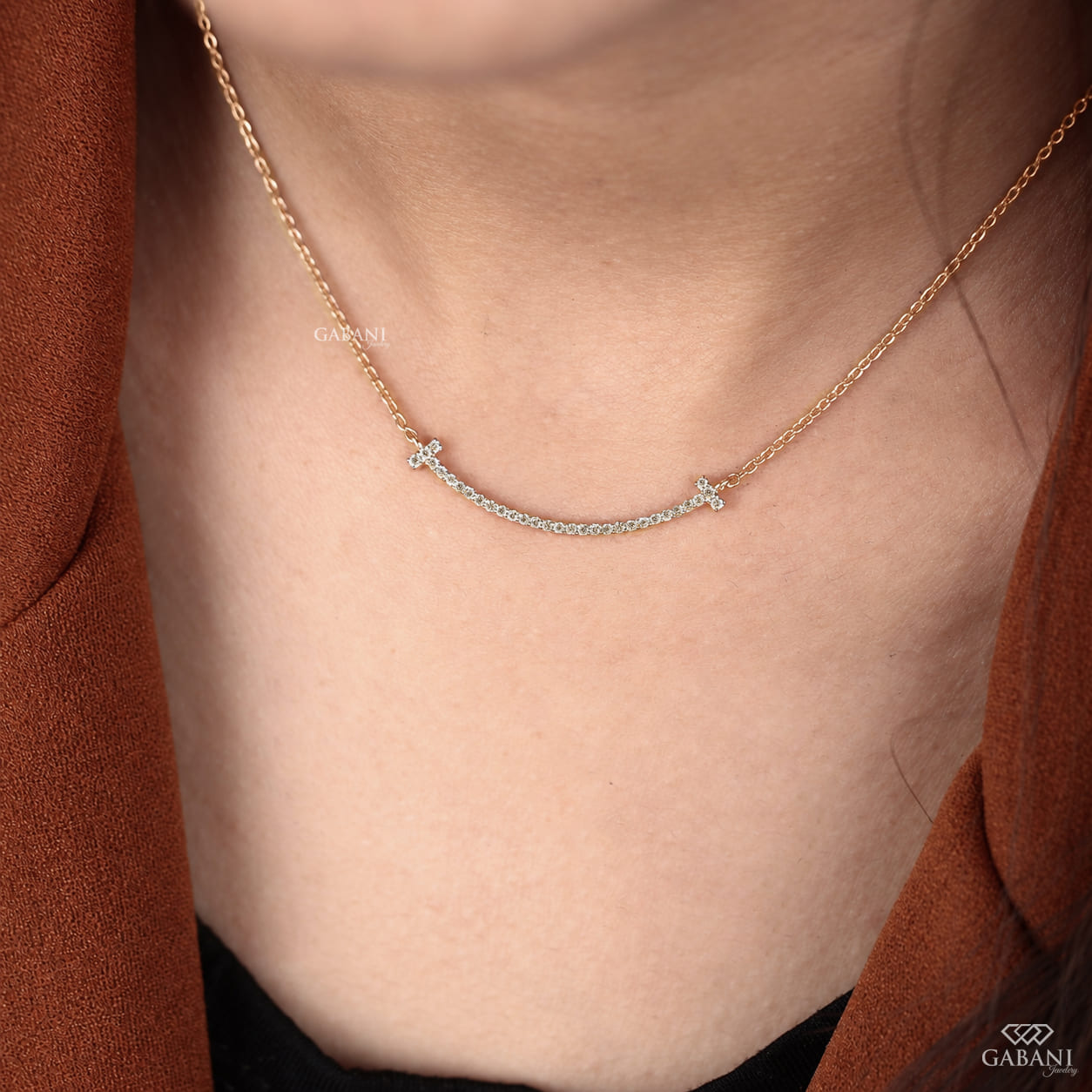 Curved bar lab grown diamond necklace in yellow gold featuring round pavé set diamonds, T-shaped ends and a delicate gold chain.