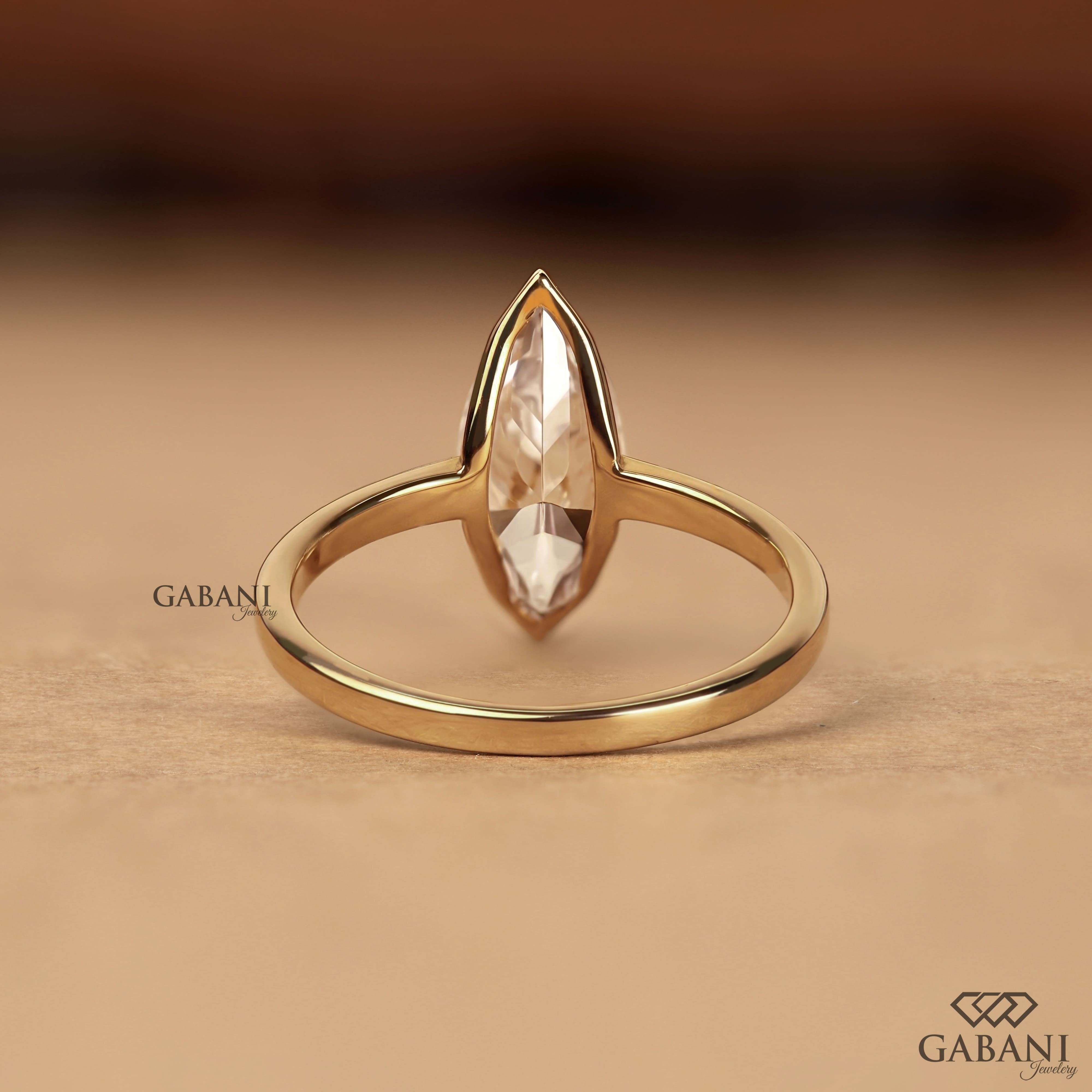 marquise scut lab grown diamond solitaire engagement ring with half bezel setting and polished 14K yellow gold band