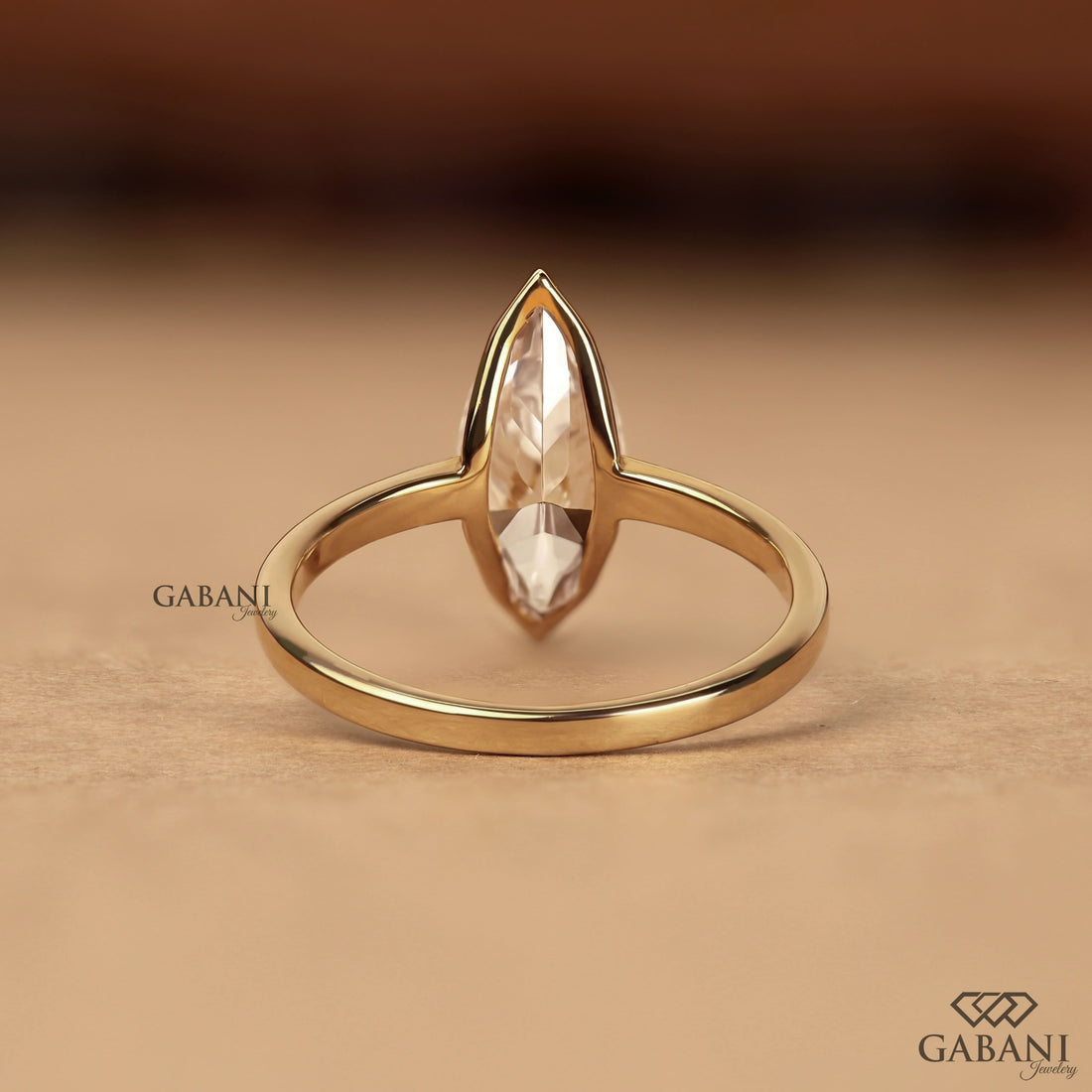 marquise scut lab grown diamond solitaire engagement ring with half bezel setting and polished 14K yellow gold band