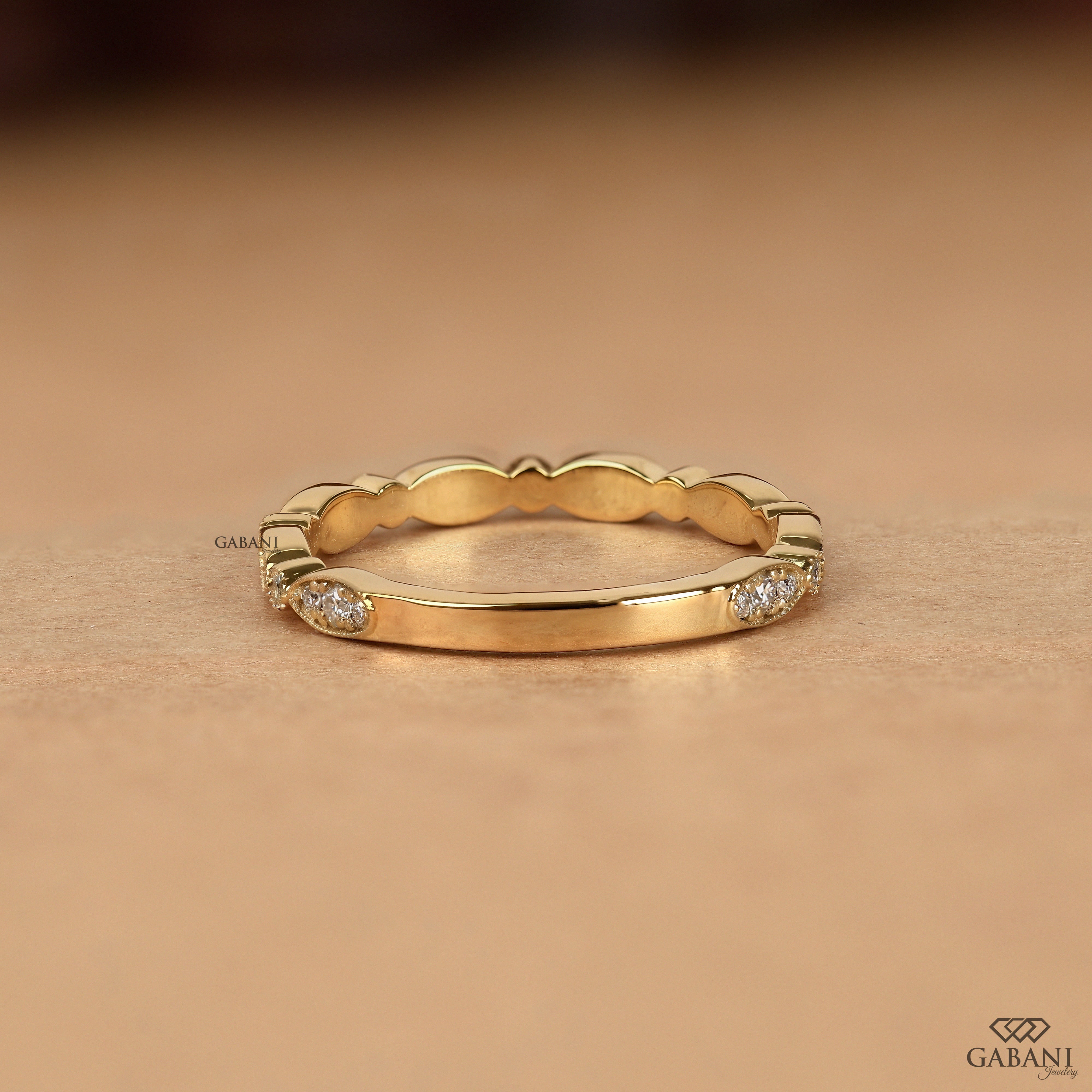 a round cut lab grown diamond wedding band in 14K yellow gold, featuring marquise-inspired diamond clusters, delicate milgrain detailing and a vintage design by Gabani Jewelry.