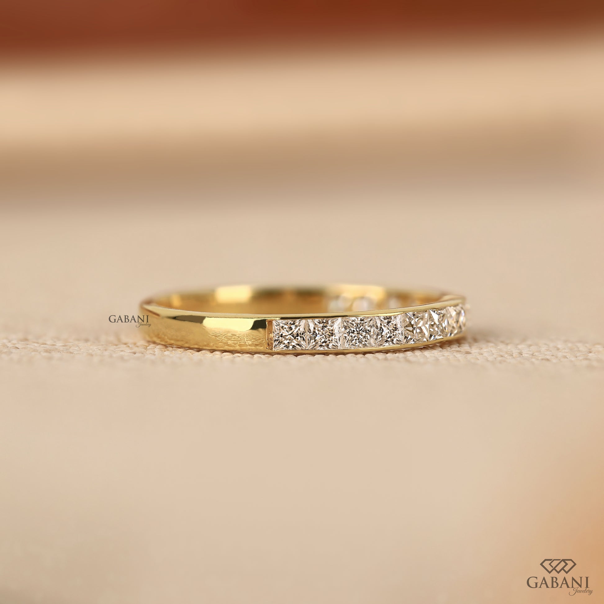 yellow gold channel set wedding band with princess cut lab grown diamonds and smooth edges