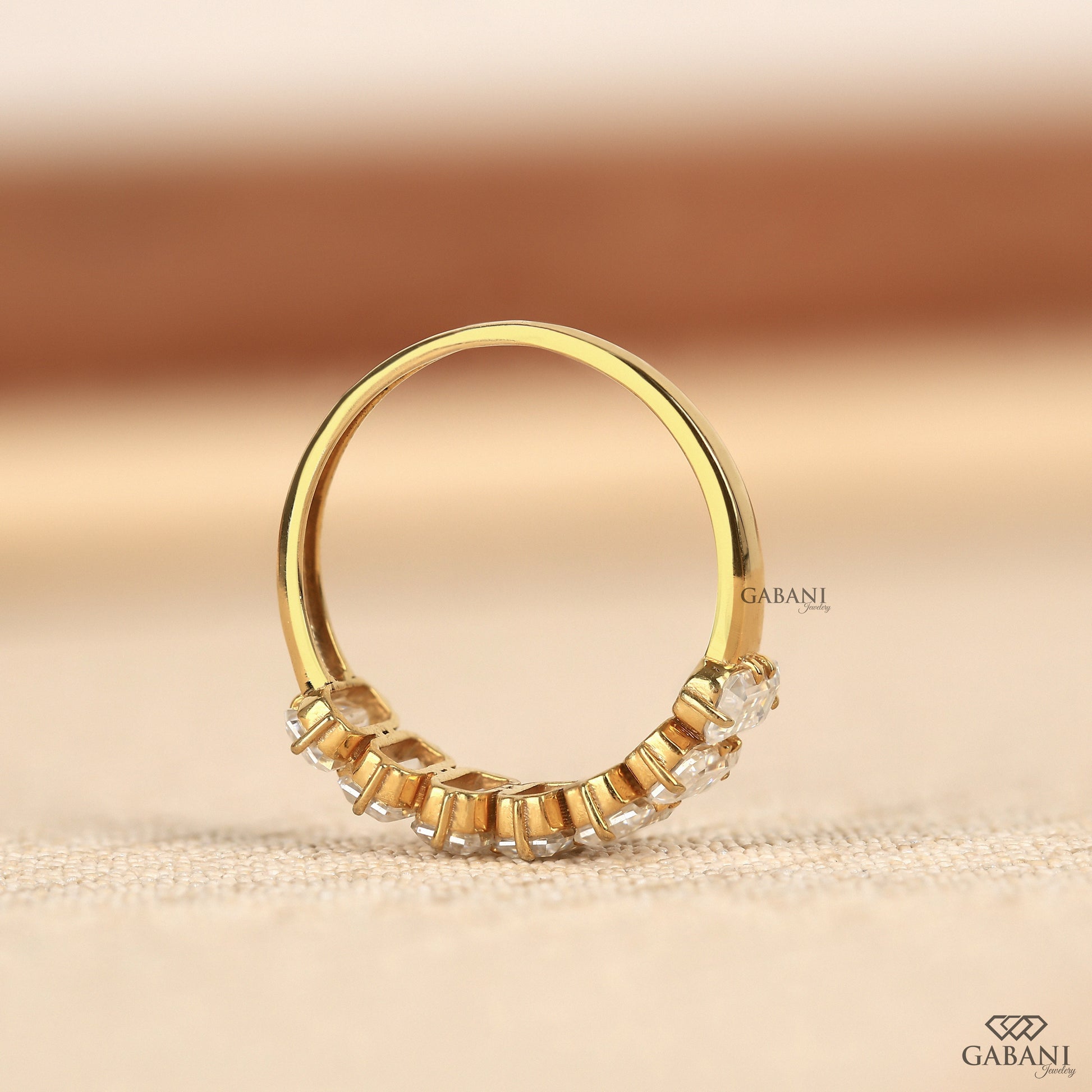 Comfort fit yellow gold band featuring seven emerald cut lab grown diamonds in half eternity style
