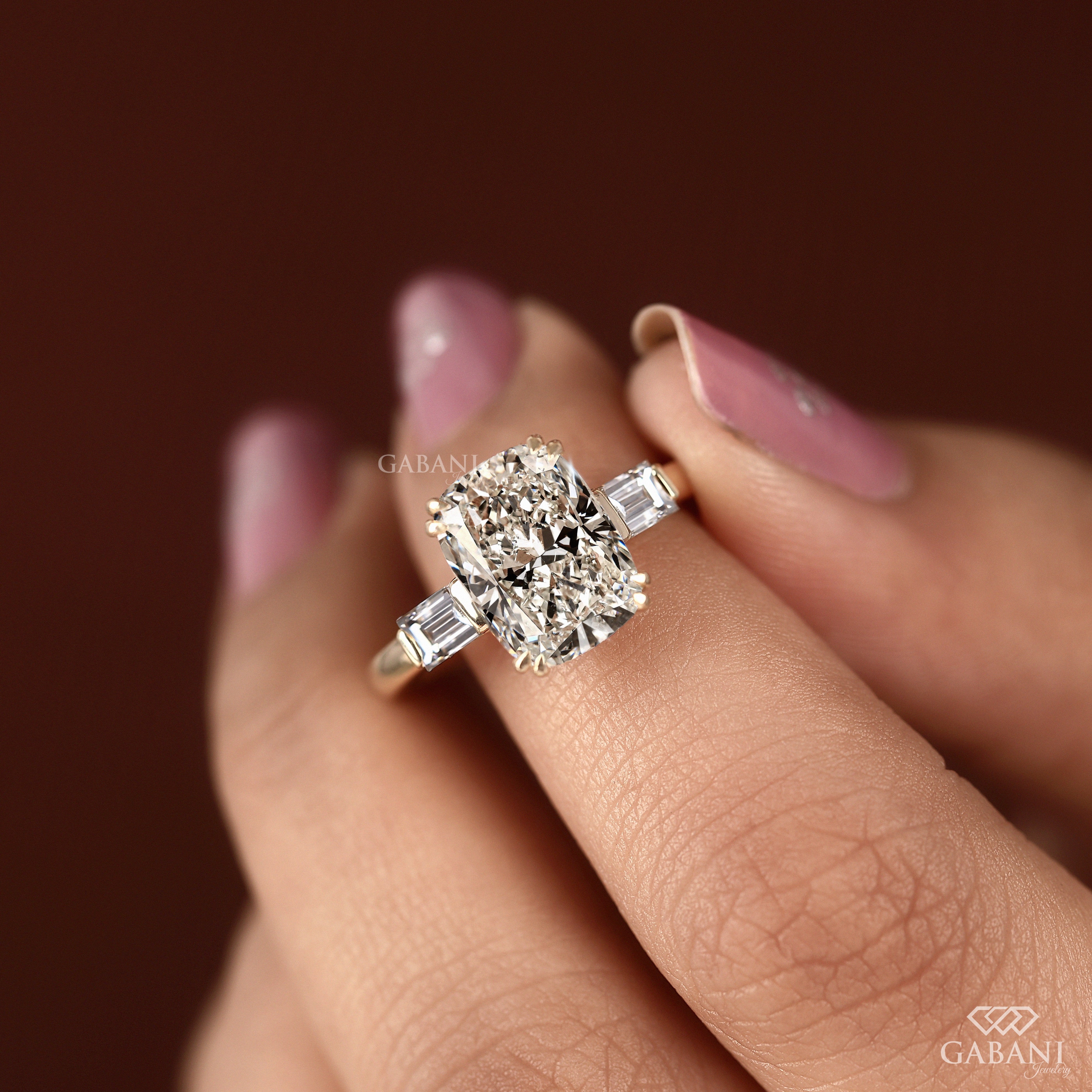 Cushion cut lab grown diamond three stone ring on model’s fingers
