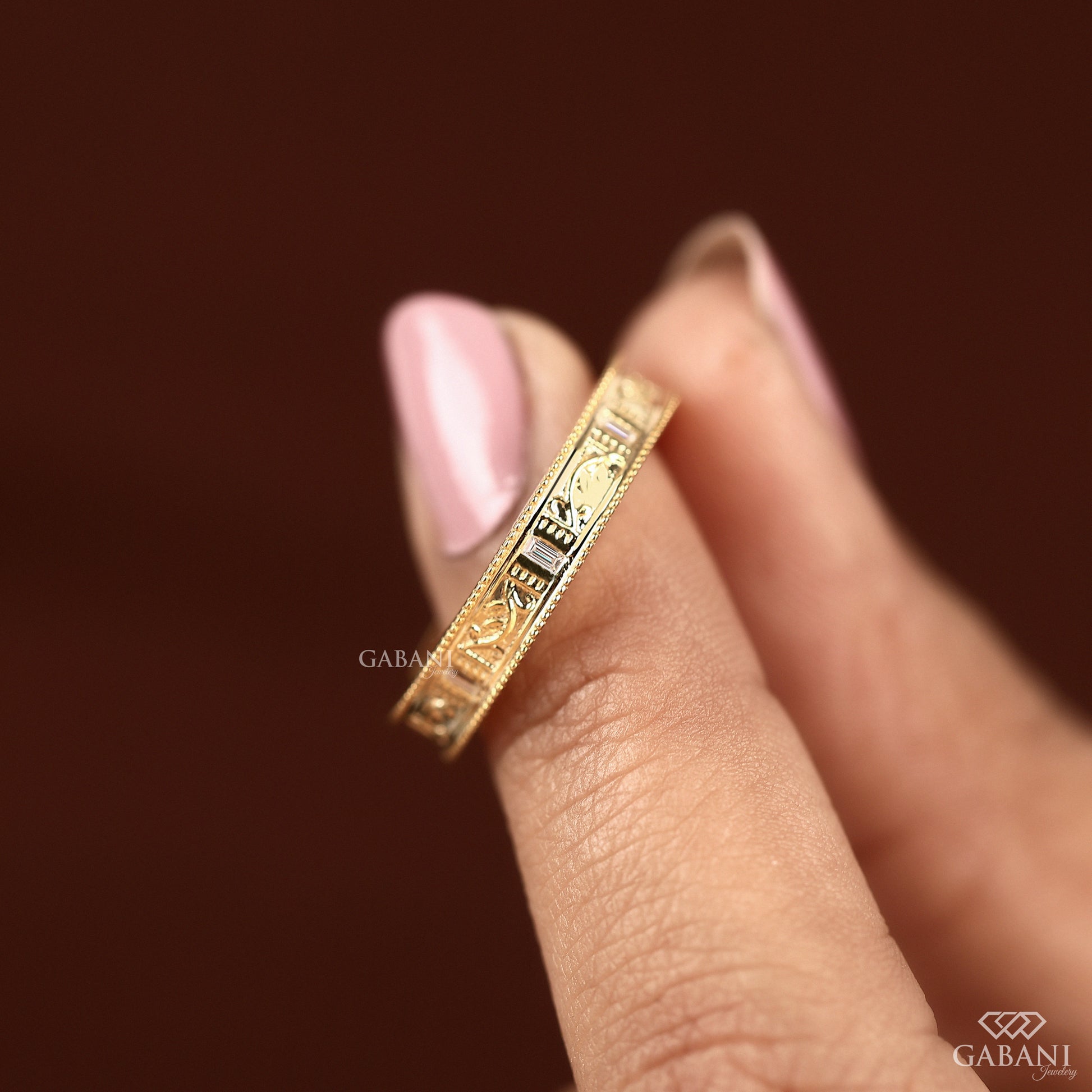 Yellow gold milgrain matching band stacked with engagement ring, showing bridal set pairing with vintage leaf design detail