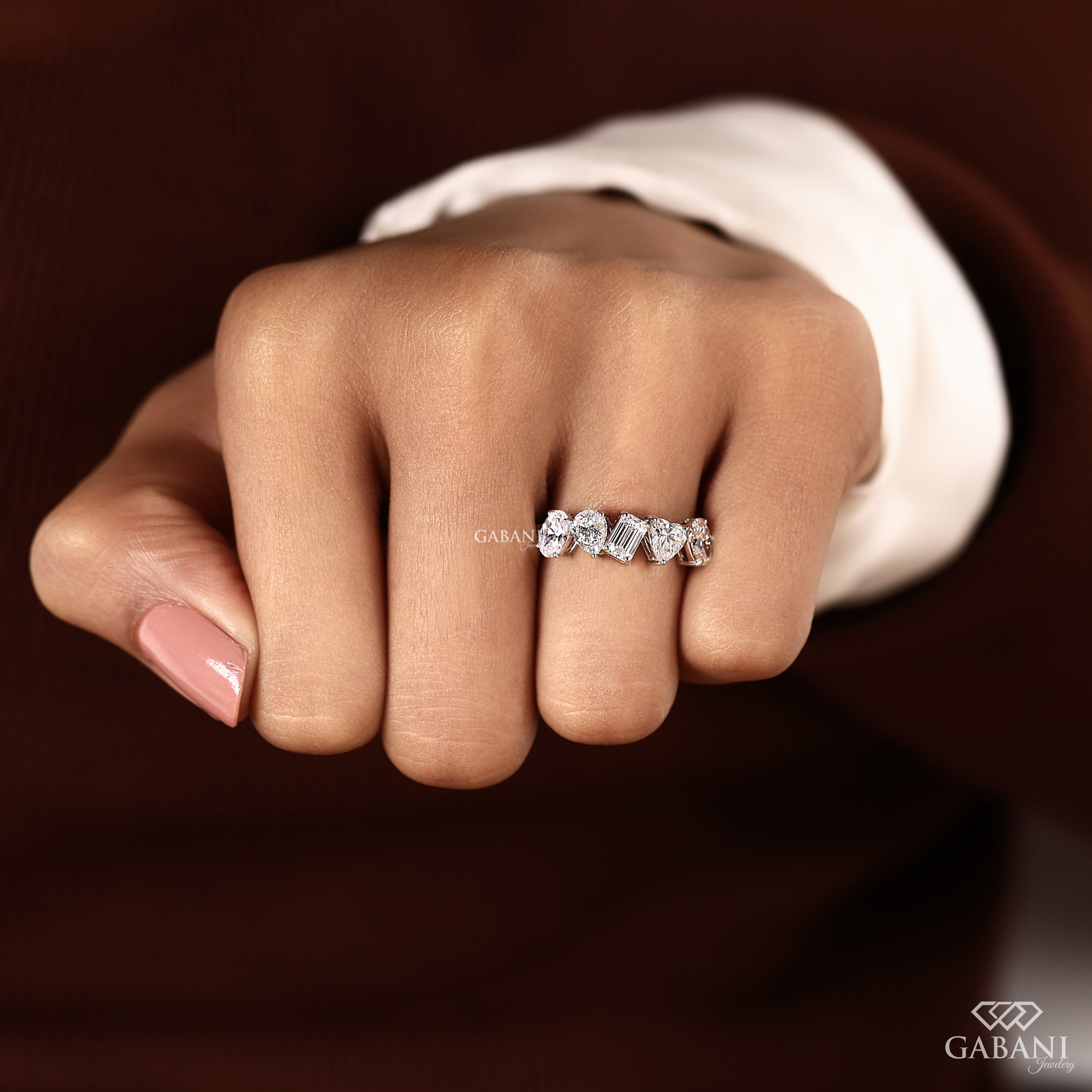 Hand holding multi shape lab grown diamond band in 14K white gold