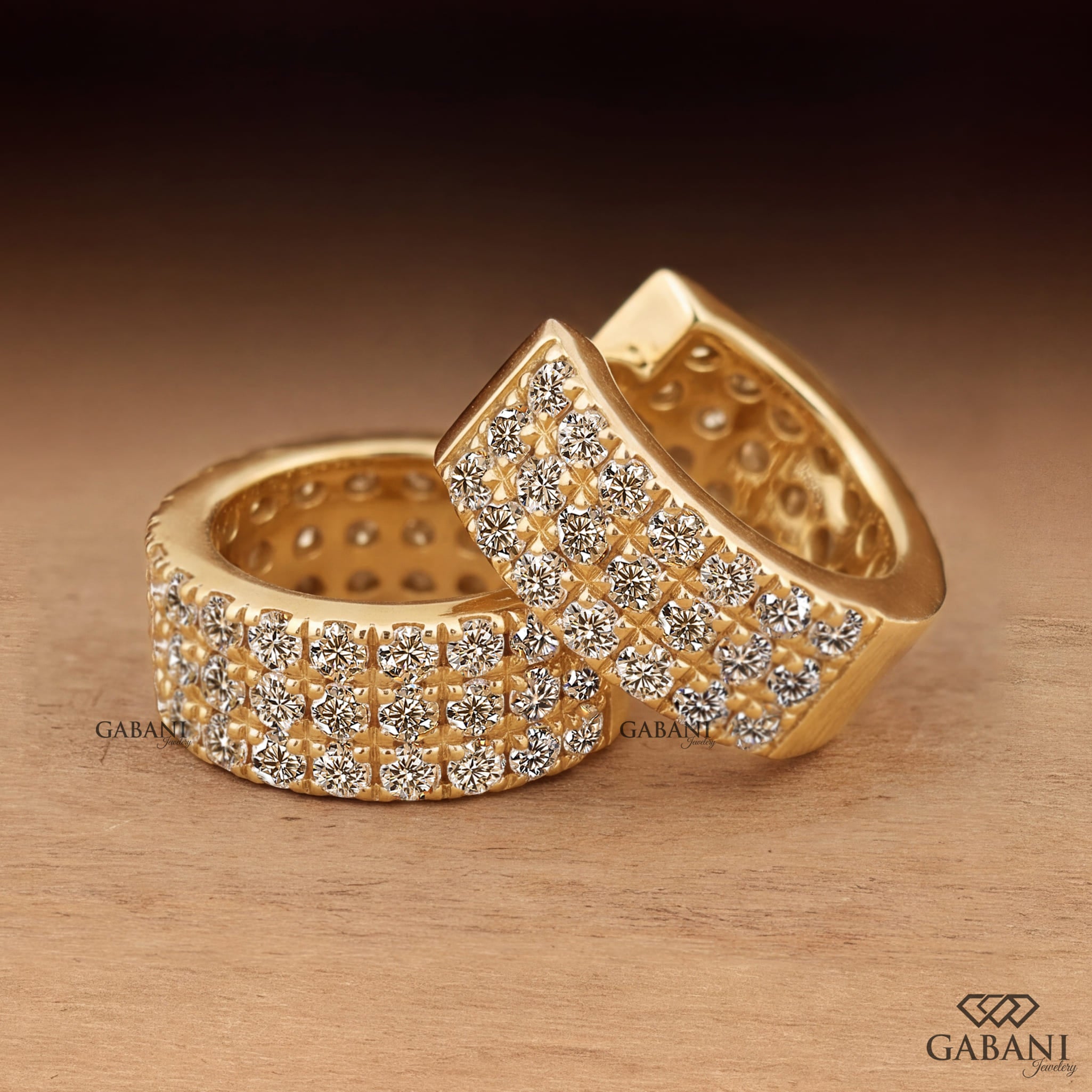 Yellow gold huggie hoop earrings with three rows of round diamonds across the front