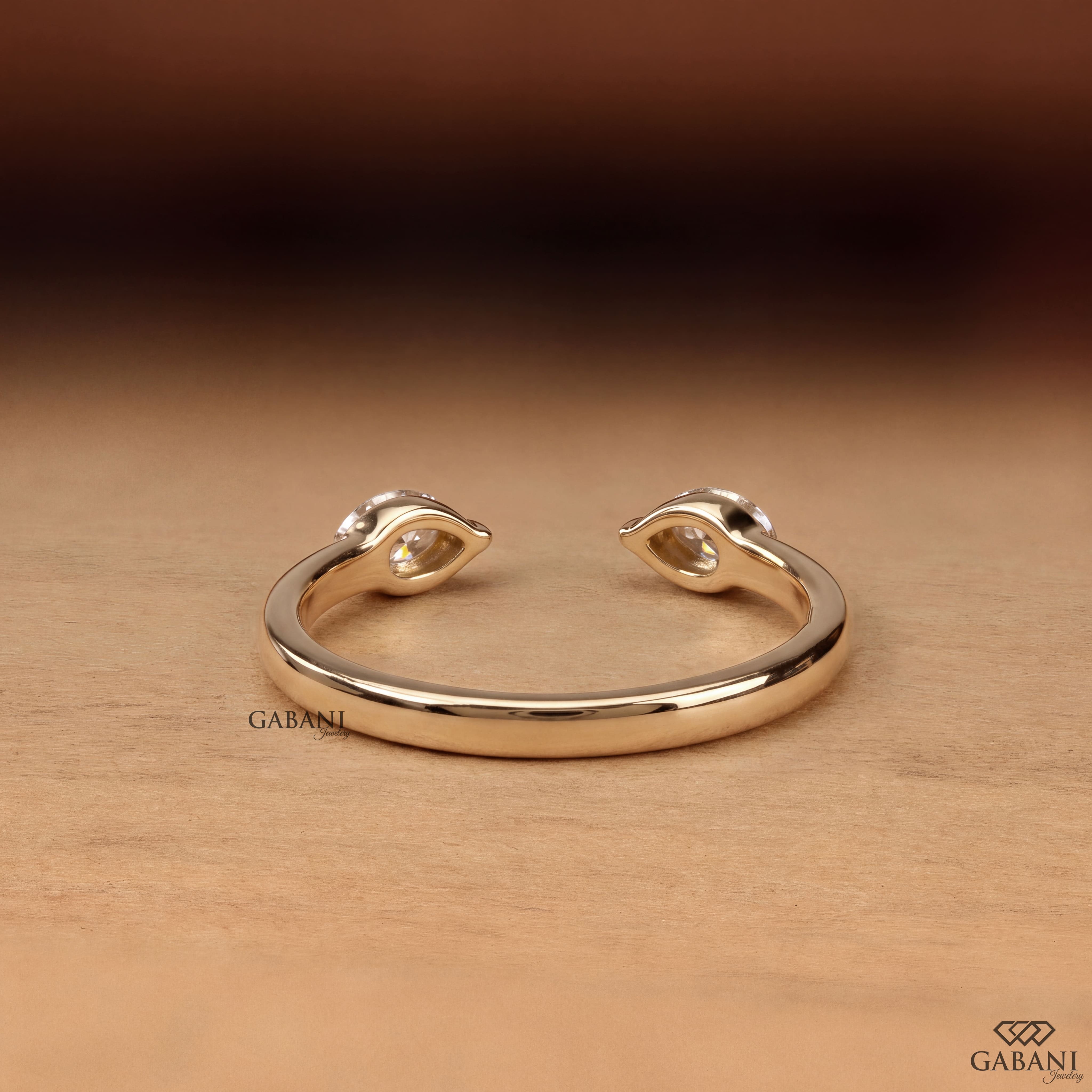 a marquise cut lab grown diamond open cuff ring in 14K yellow gold, featuring two horizontally set marquise diamonds in elegant half bezel settings with a modern minimalist design by Gabani Jewelry.