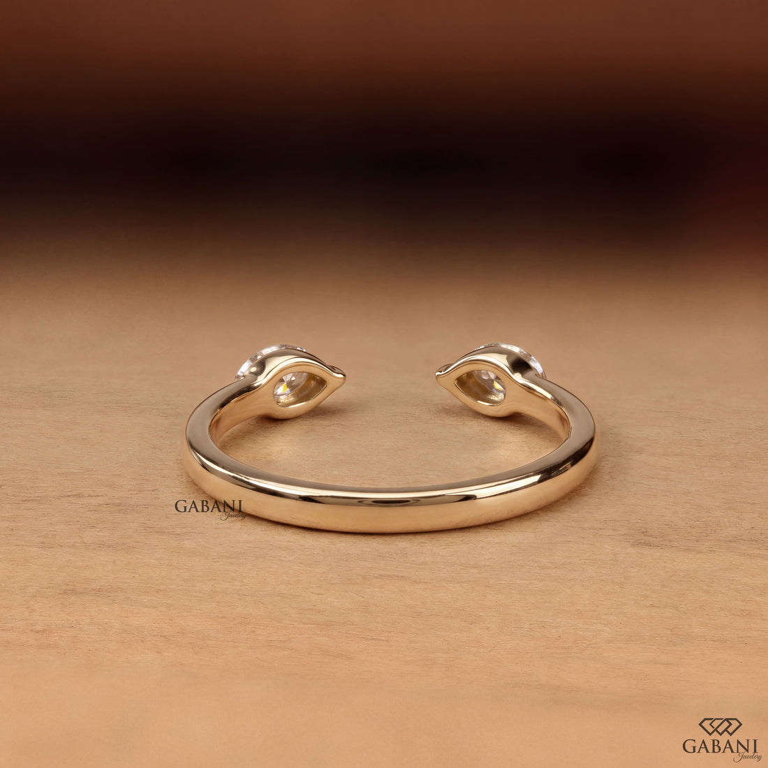 a marquise cut lab grown diamond open cuff ring in 14K yellow gold, featuring two horizontally set marquise diamonds in elegant half bezel settings with a modern minimalist design by Gabani Jewelry.