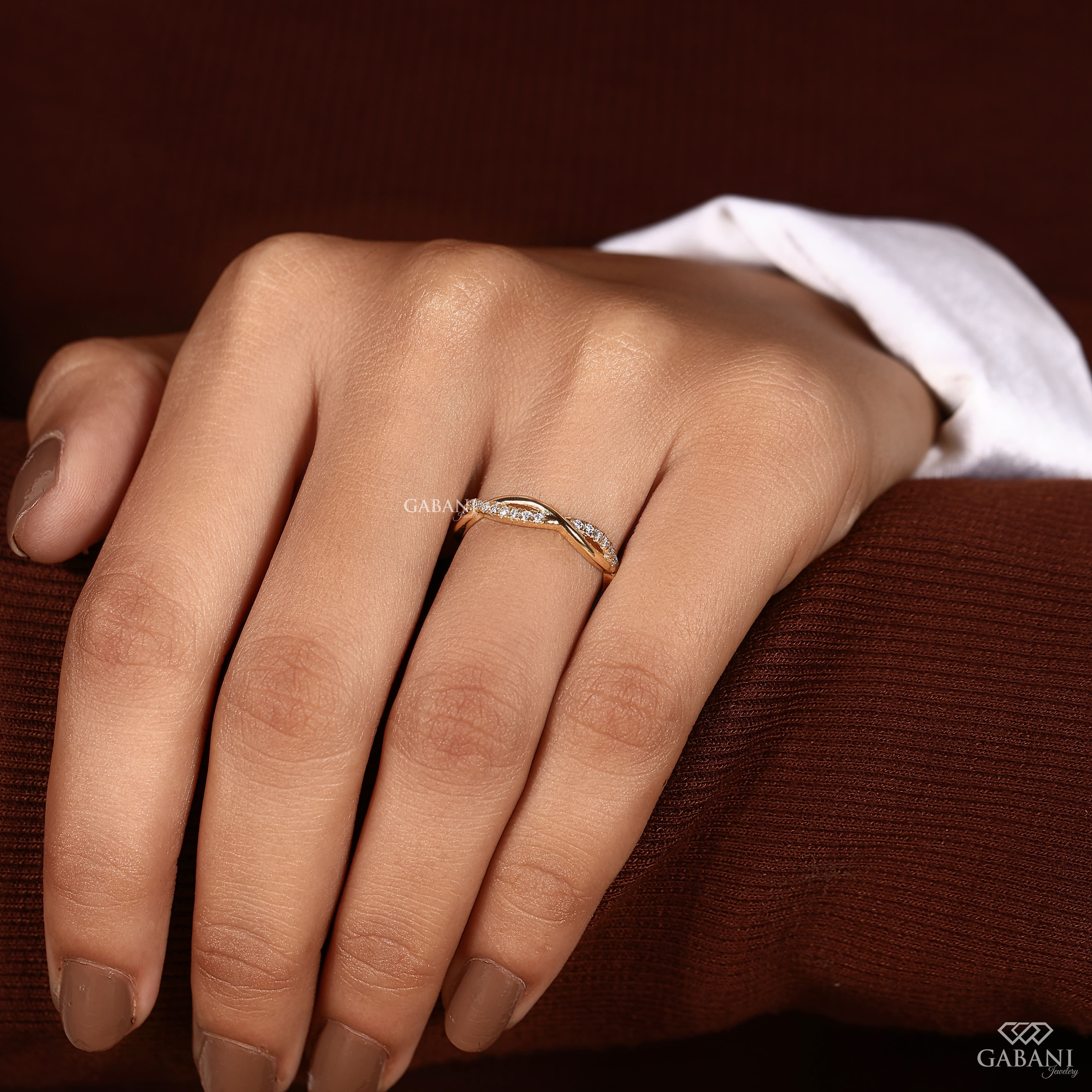 Twisted full eternity lab grown diamond band in yellow gold with round cut diamonds and an infinity inspired crossover design for wedding, anniversary, and stackable wear.