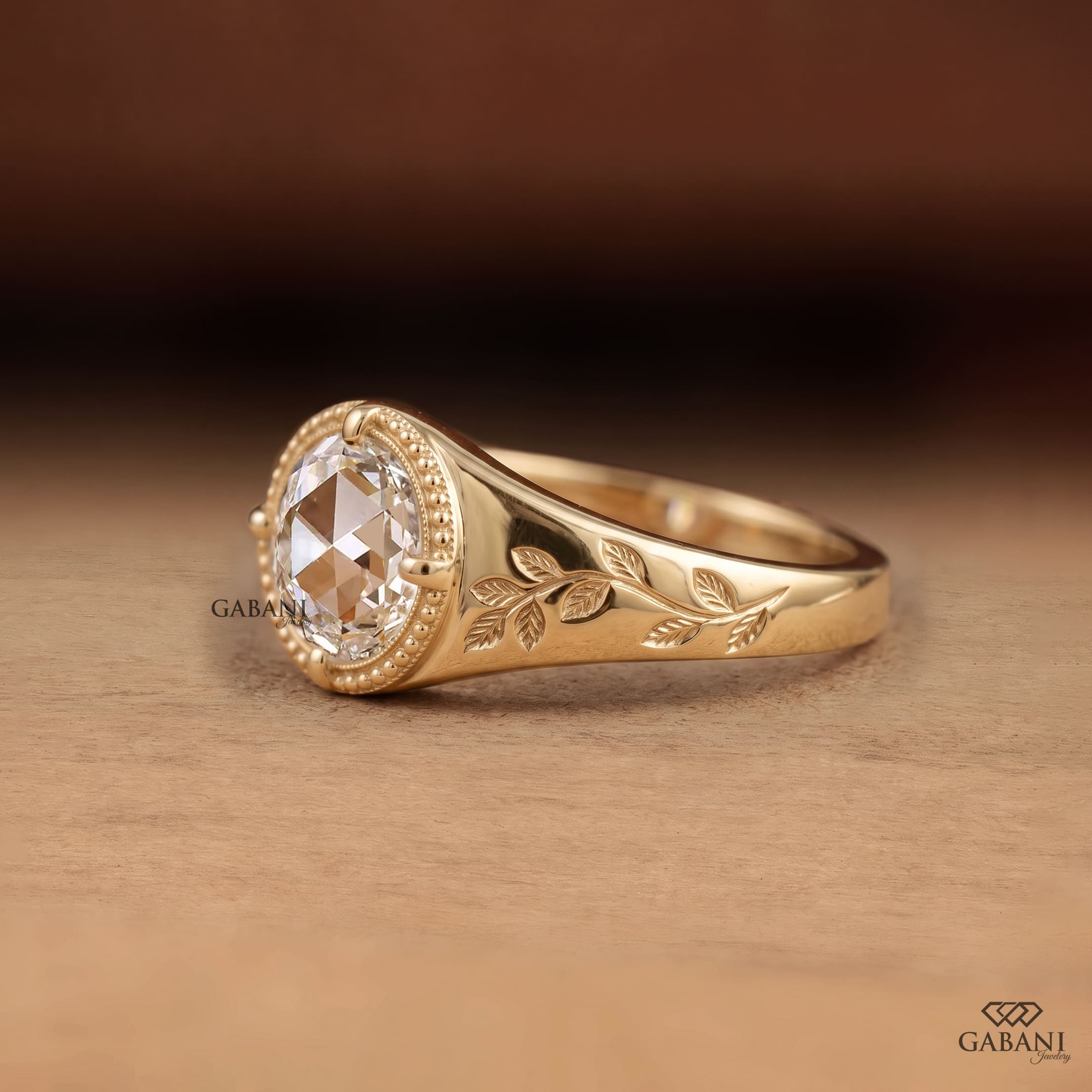 Round rose cut lab grown diamond signet ring with four prong setting, leaf engraving, beaded detailing and yellow gold band.
