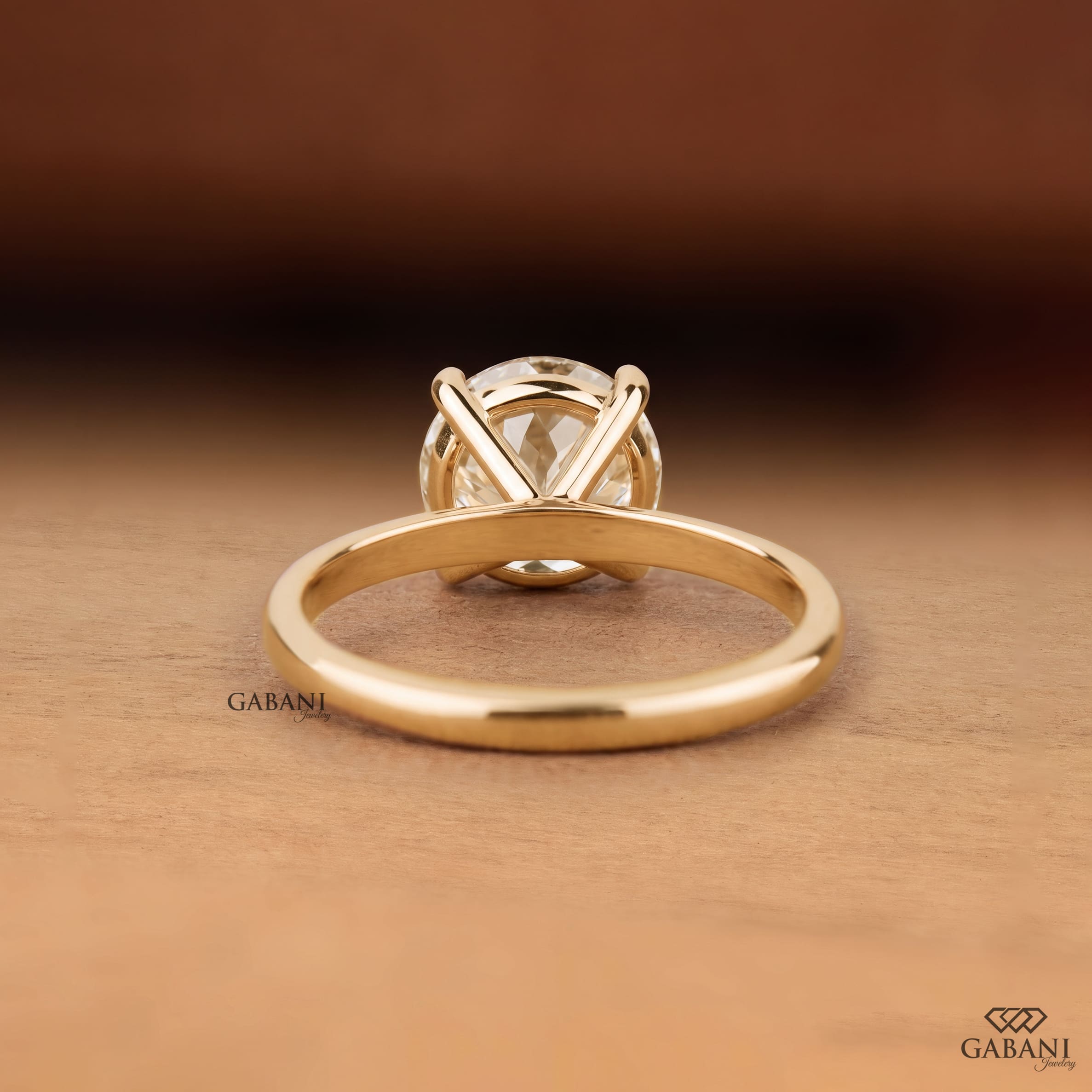 Round cut lab grown diamond solitaire engagement ring with four-prong setting and polished yellow gold band.