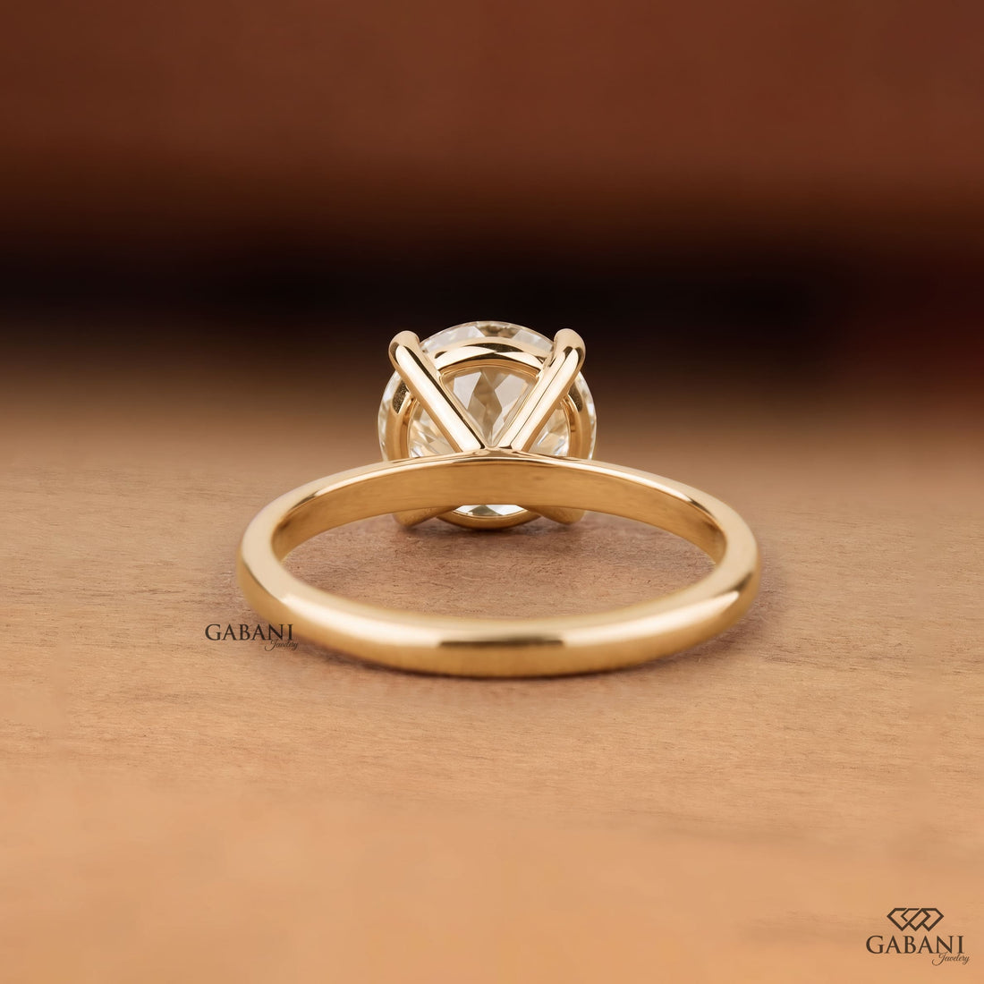 Round cut lab grown diamond solitaire engagement ring with four-prong setting and polished yellow gold band.