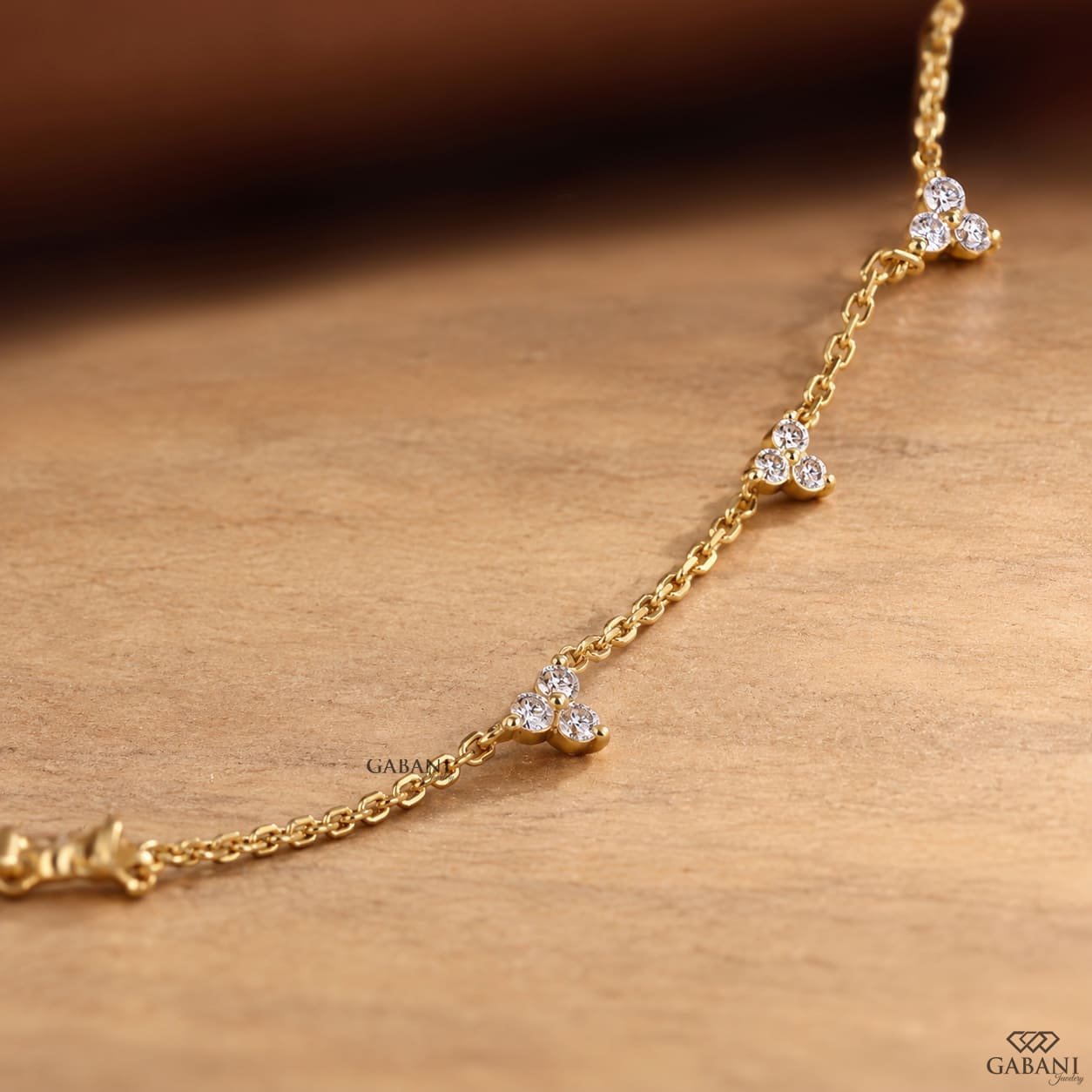 18K yellow gold lab grown diamond station necklace featuring round cut three stone floral clusters on a delicate gold chain.