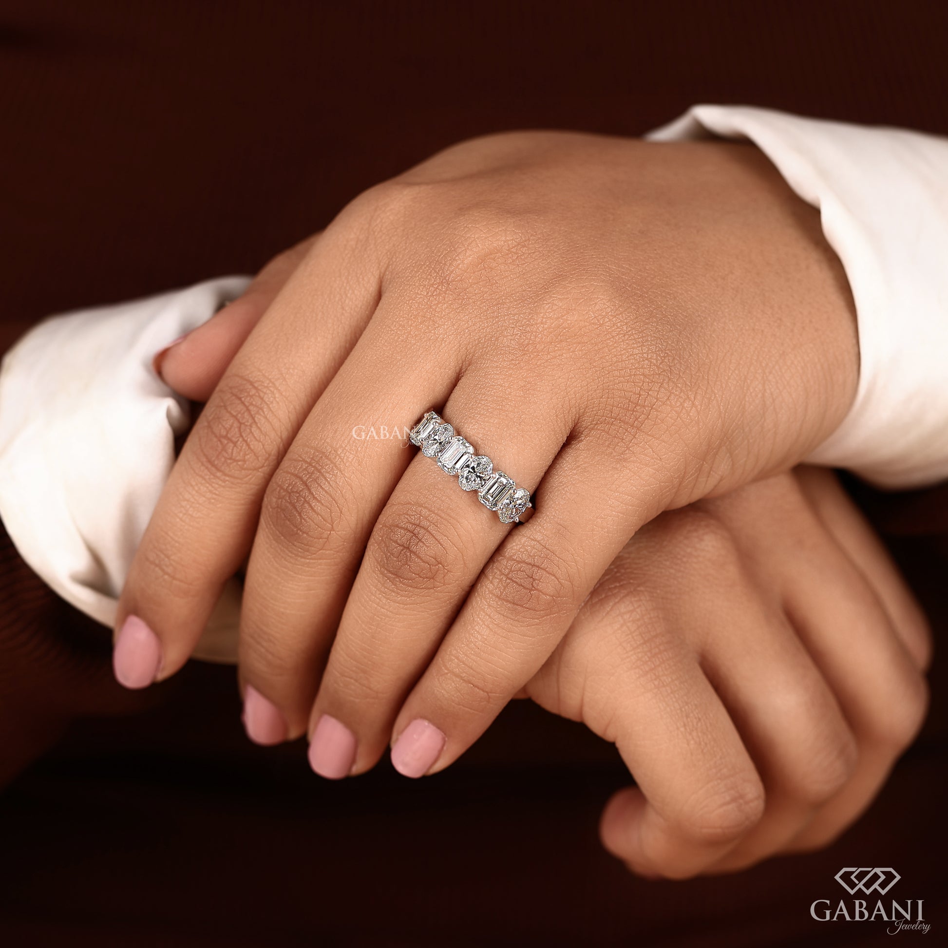 white gold comfort fit ring with alternating emerald and oval diamonds