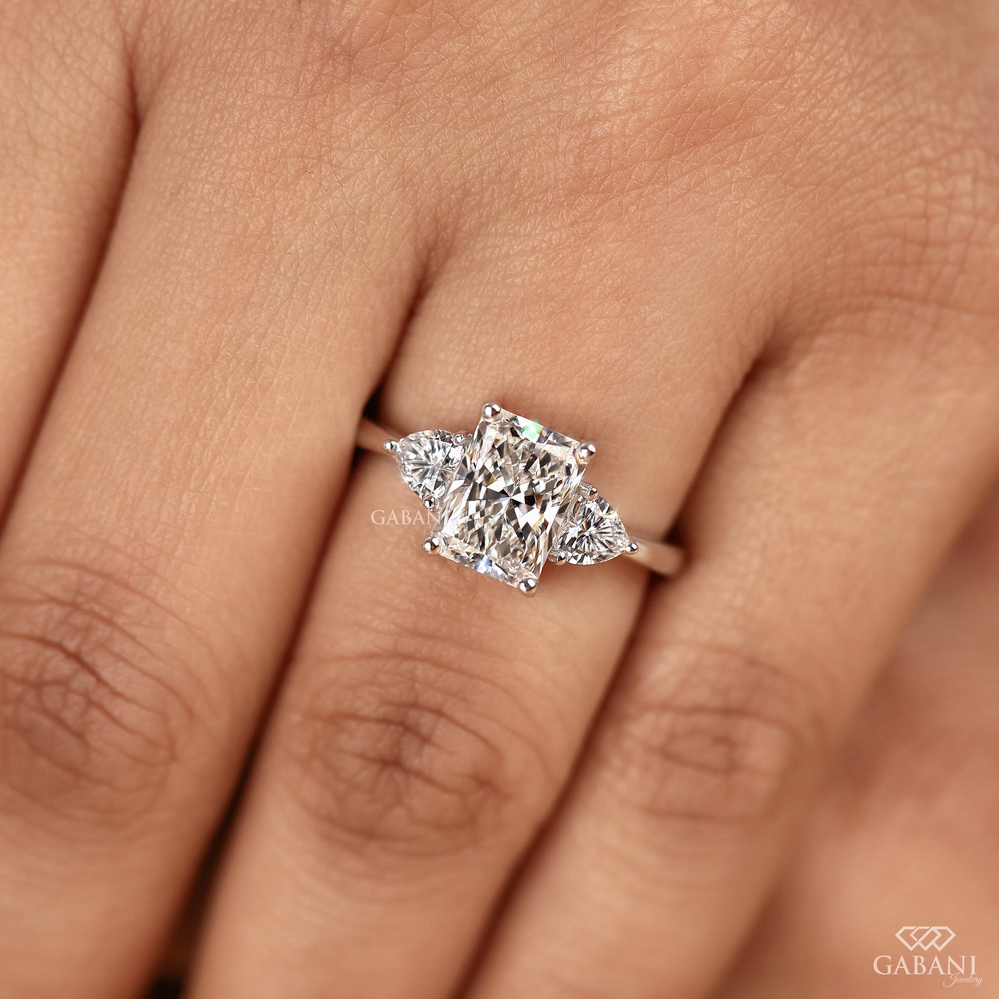 Handcrafted radiant cut lab grown diamond three stone ring with heart accents in white gold
