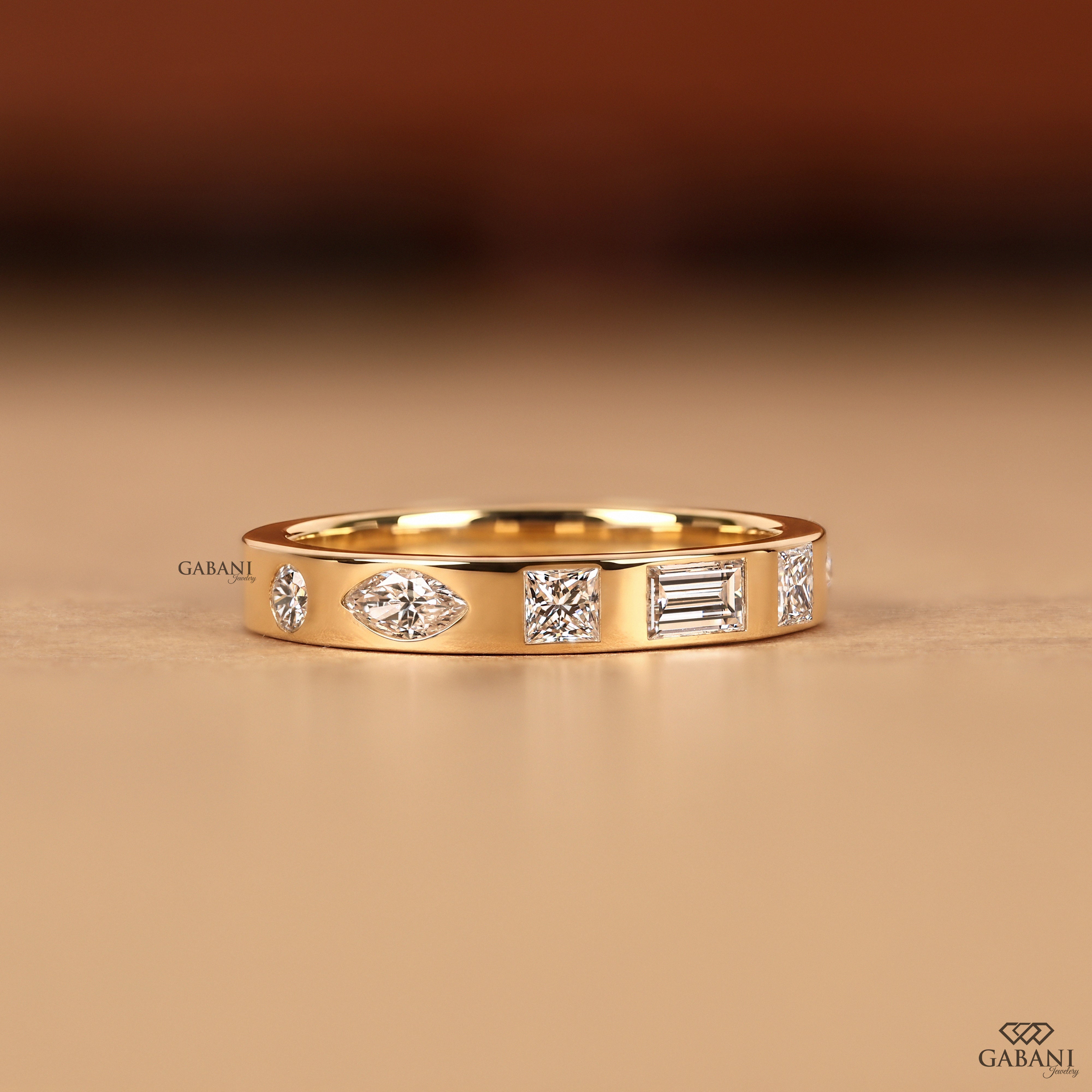 Gabani Jewelry flat flush setting band with lab grown diamonds in princess, baguette, round, and marquise shapes for stacking with engagement rings and bridal sets.