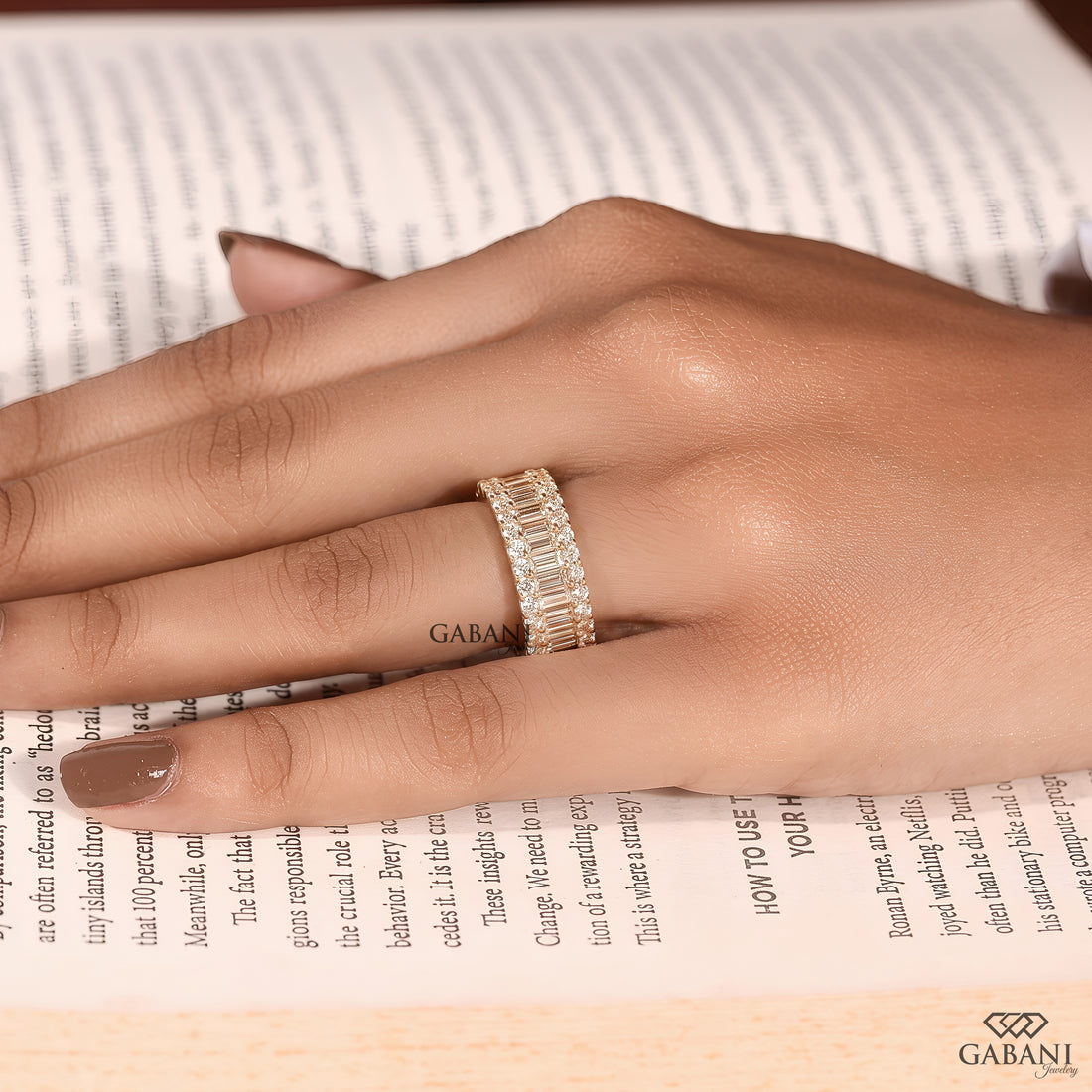 Front display of a wide yellow gold wedding band featuring standing baguette and round lab grown diamonds