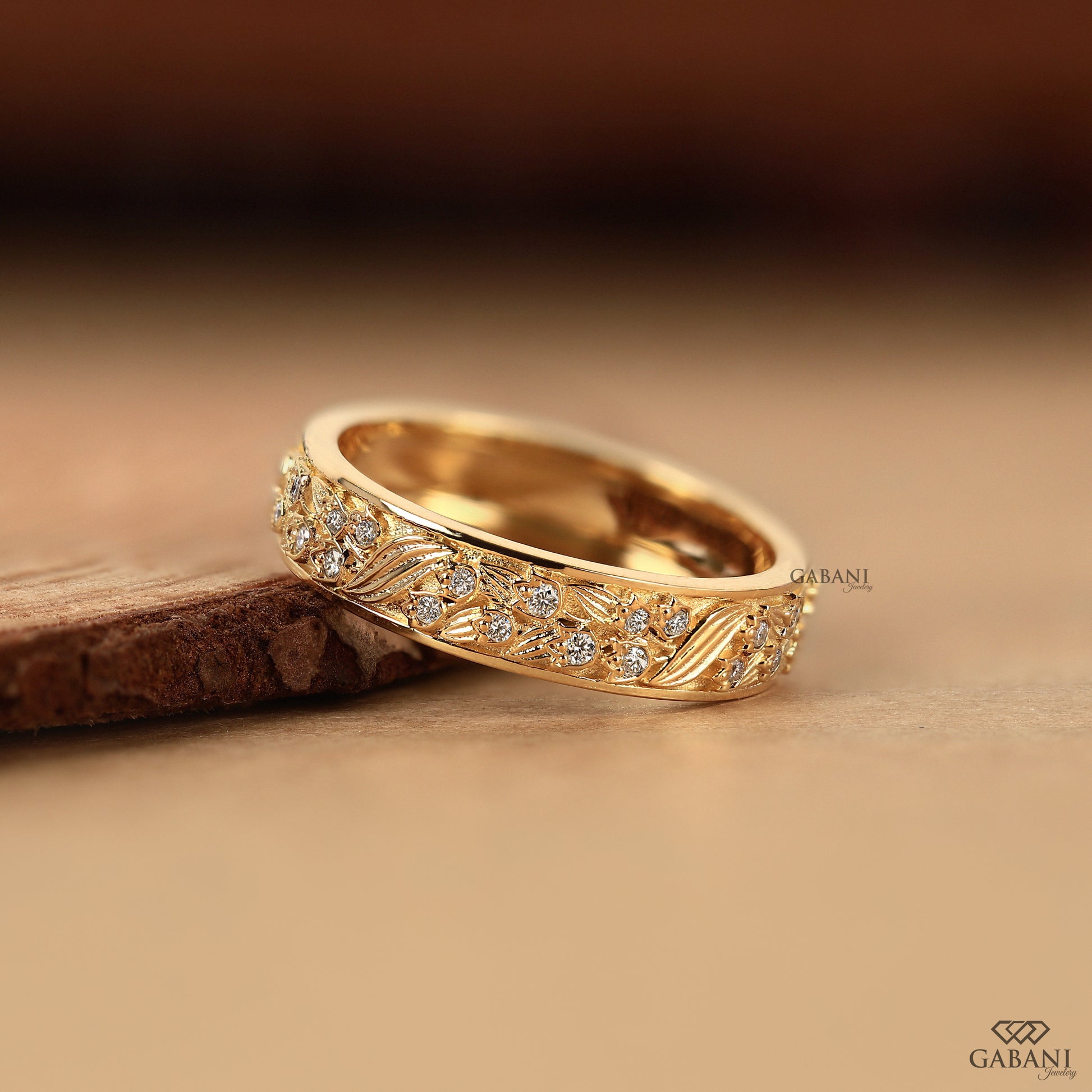 yellow gold nature inspired stacking band with leaf engraved pattern