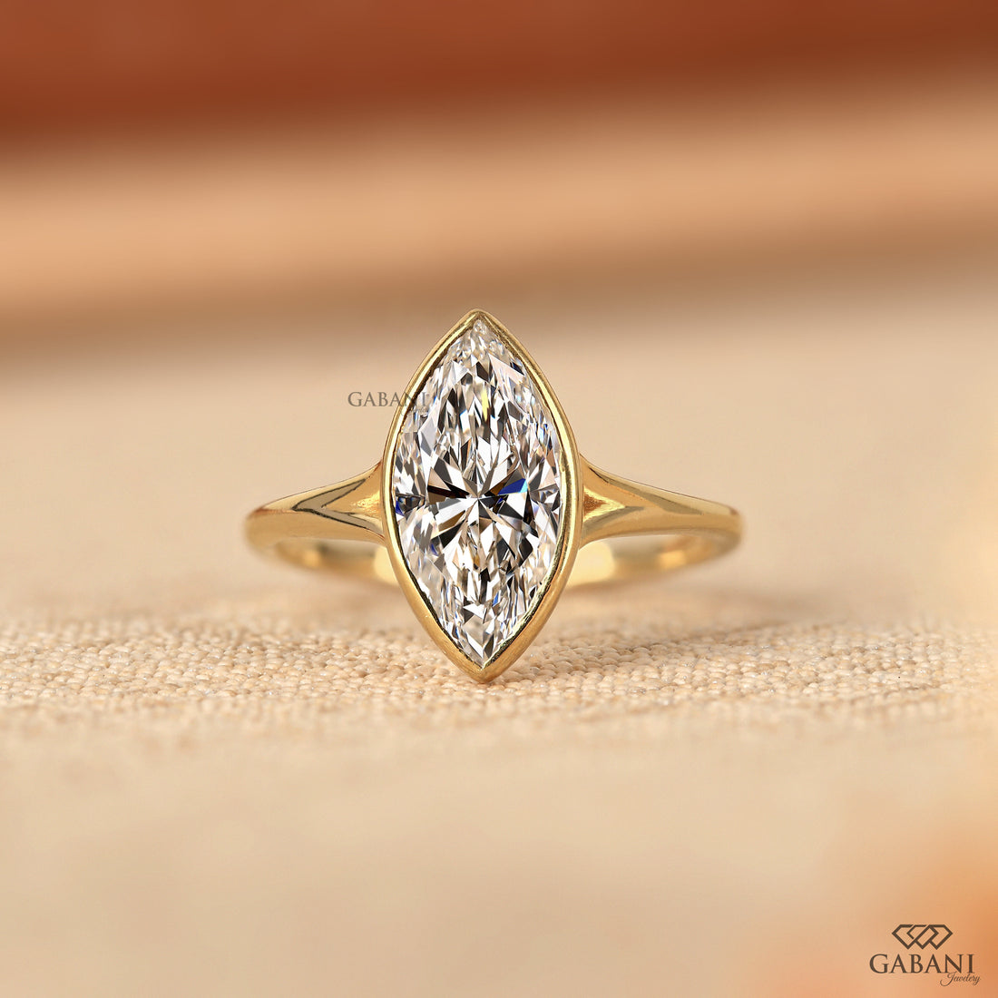 marquise cut diamond solitaire engagement ring with full bezel setting in yellow gold